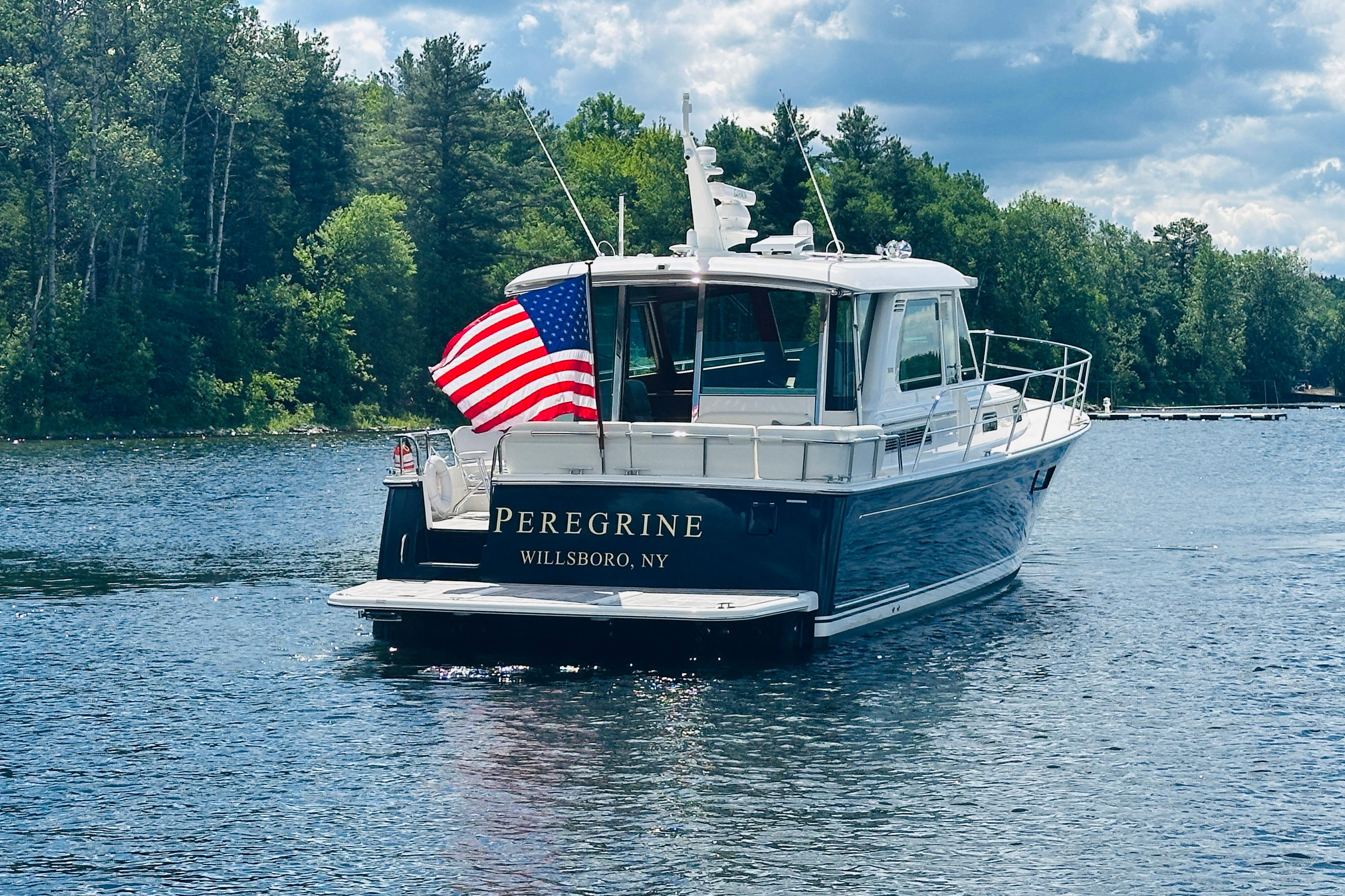 2025 Sabre 48 Salon Express boat on a lake with American flag.
