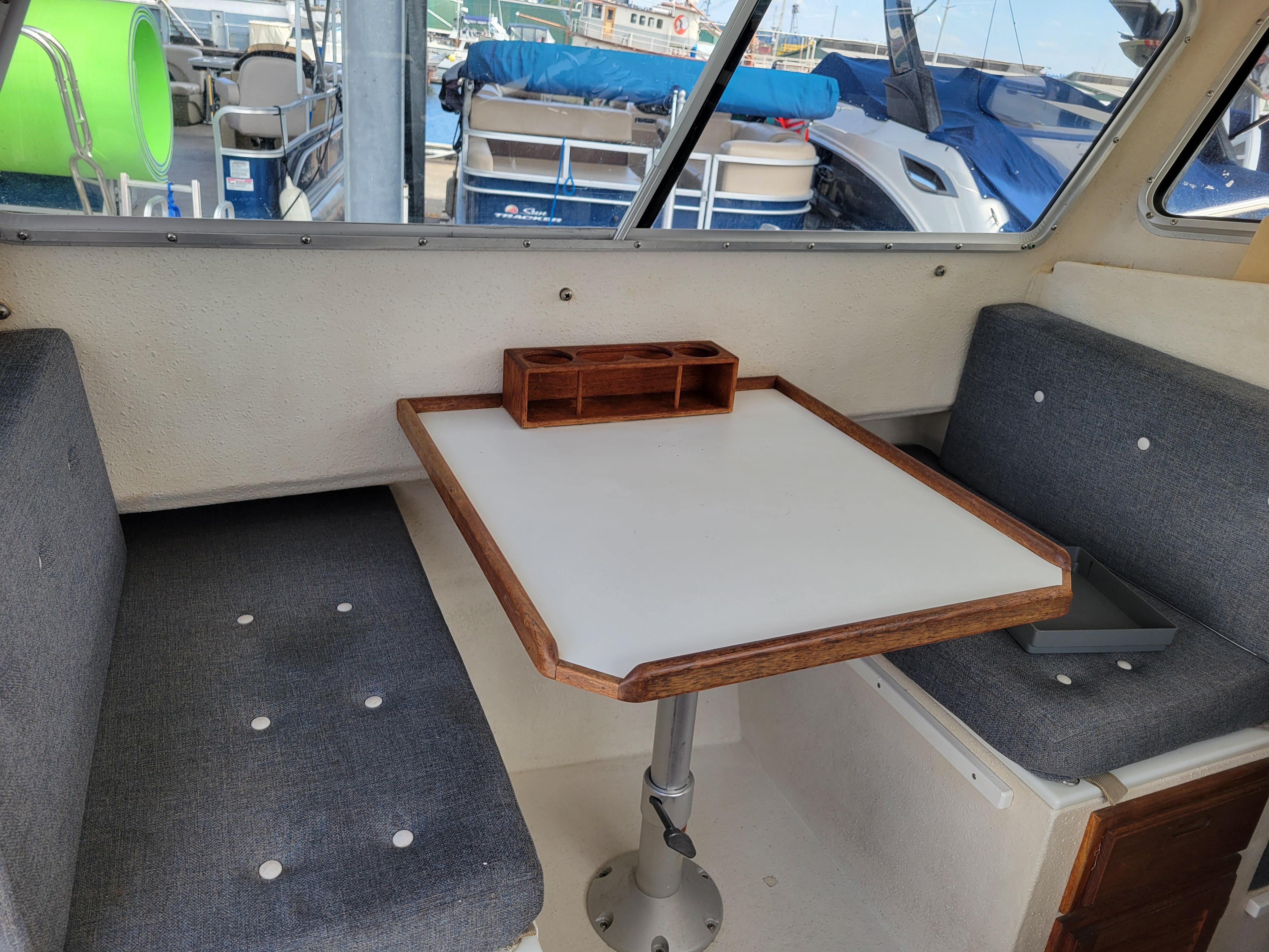 Interior of 1999 SeaSport 2400 XL Limited boat with table and seating.