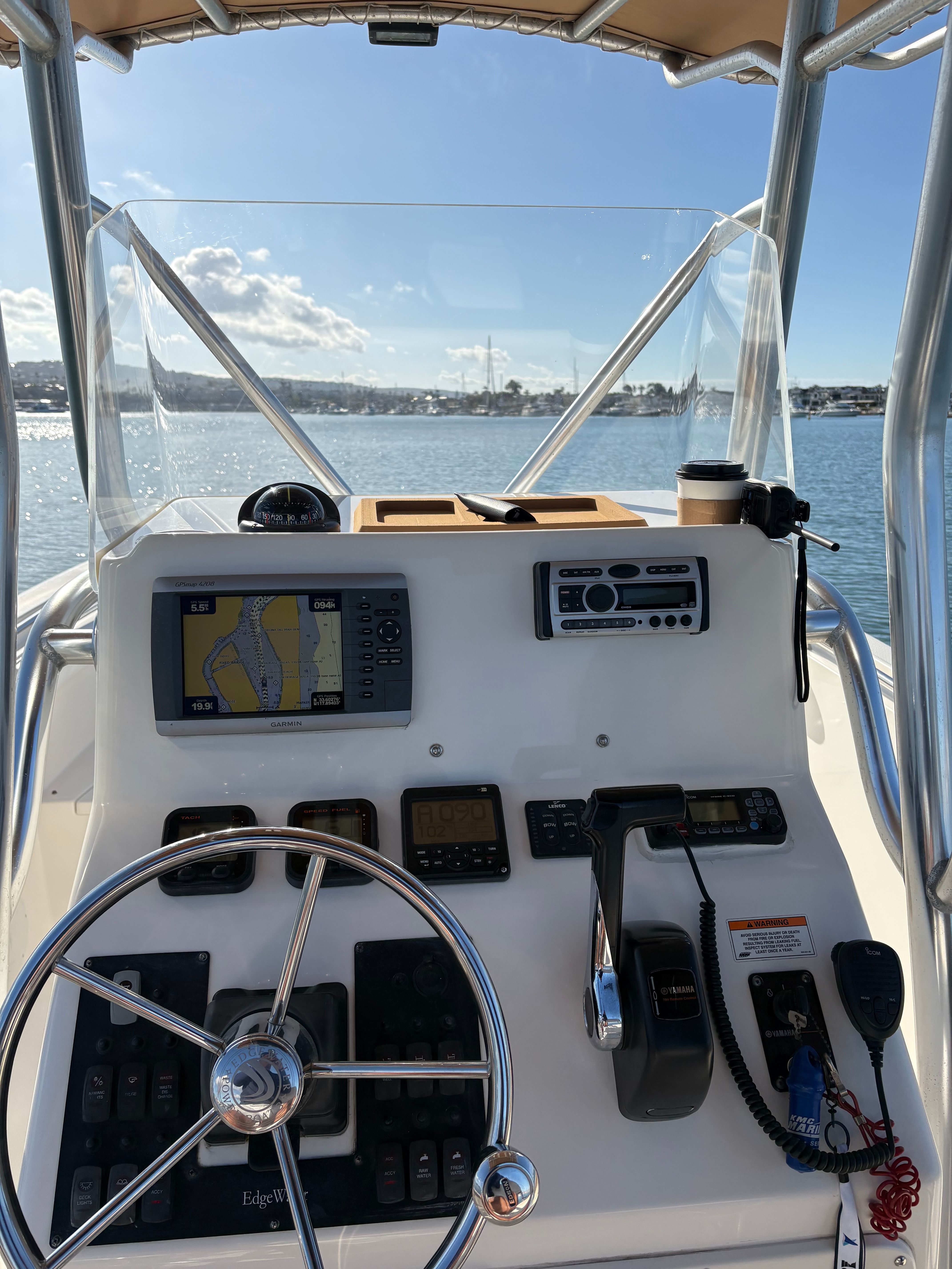Helm of a 2008 Edgewater 228CC boat on calm waters.