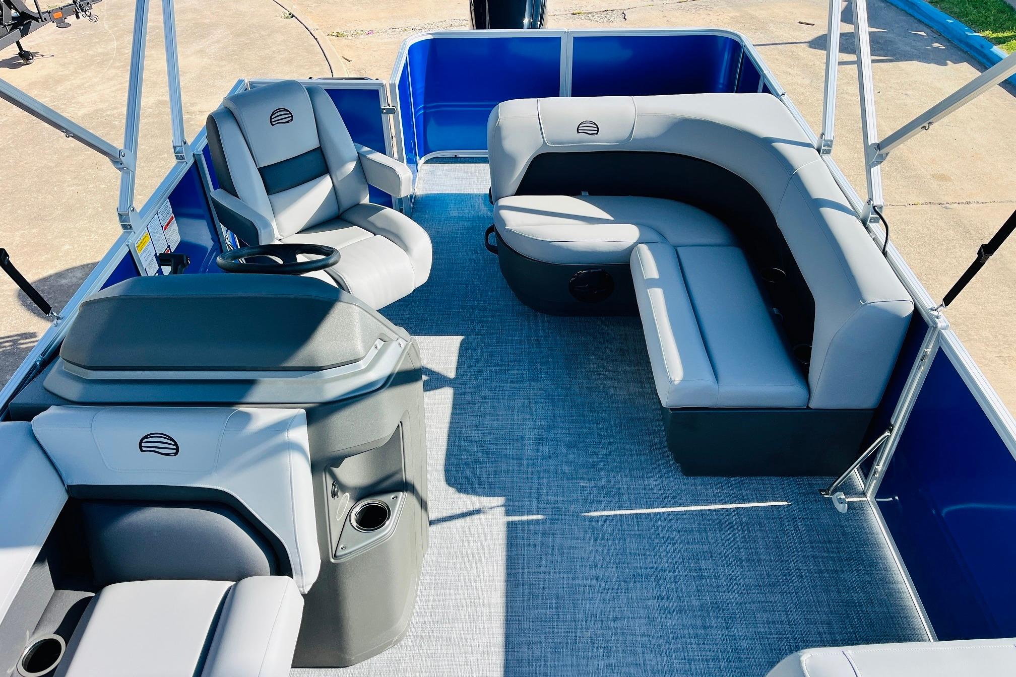 2026 Sun Tracker Party Barge 18 DLX interior with gray seating and blue accents.