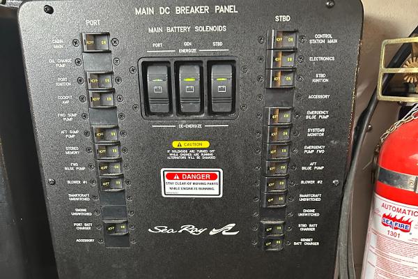 Main DC breaker panel of 2004 Sea Ray 380 Sundancer with safety warnings and fire extinguisher.