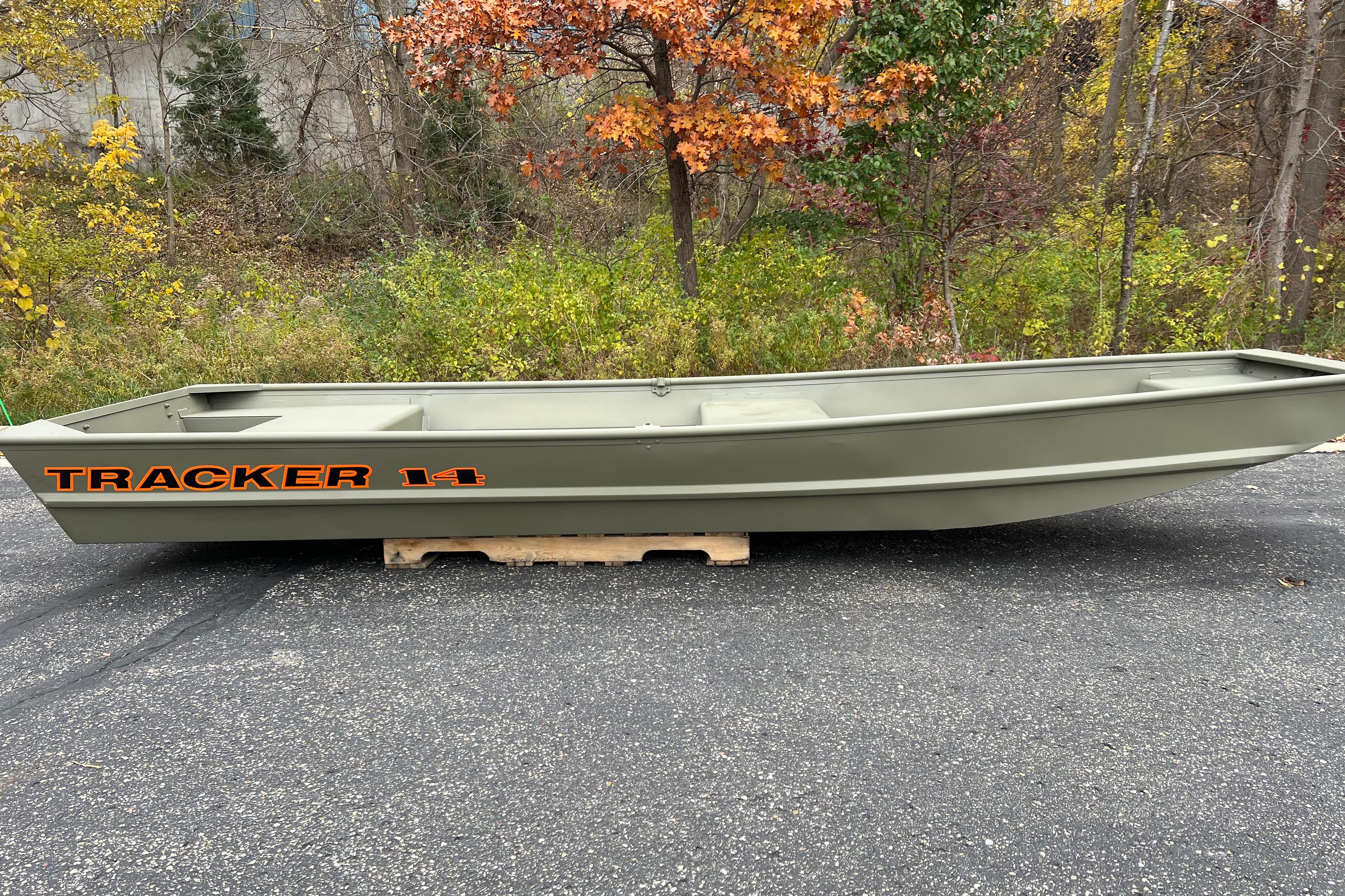 2026 Tracker Grizzly 14 Jon boat on pavement, surrounded by autumn foliage.