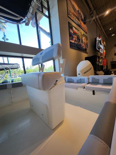 2025 Mako 214 CC boat interior with seating, displayed in a showroom setting.