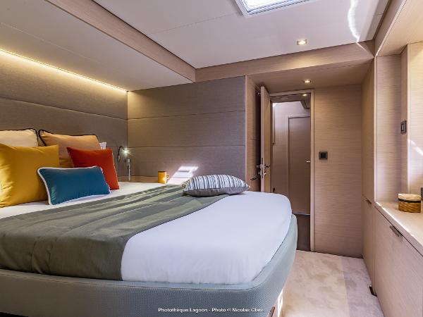 Luxurious bedroom interior of 2025 Lagoon 55 yacht with modern design and cozy bedding.