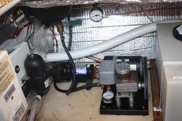 Engine room of a 1985 Nordic Tug 26 with various equipment and pipes.