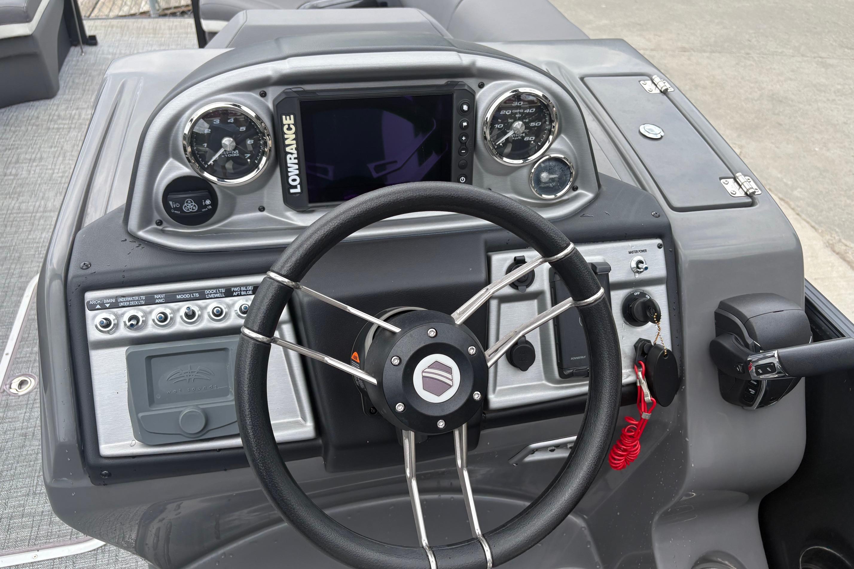 Dashboard of 2023 South Bay 525 RS 3.0 Arch boat with steering wheel and controls.