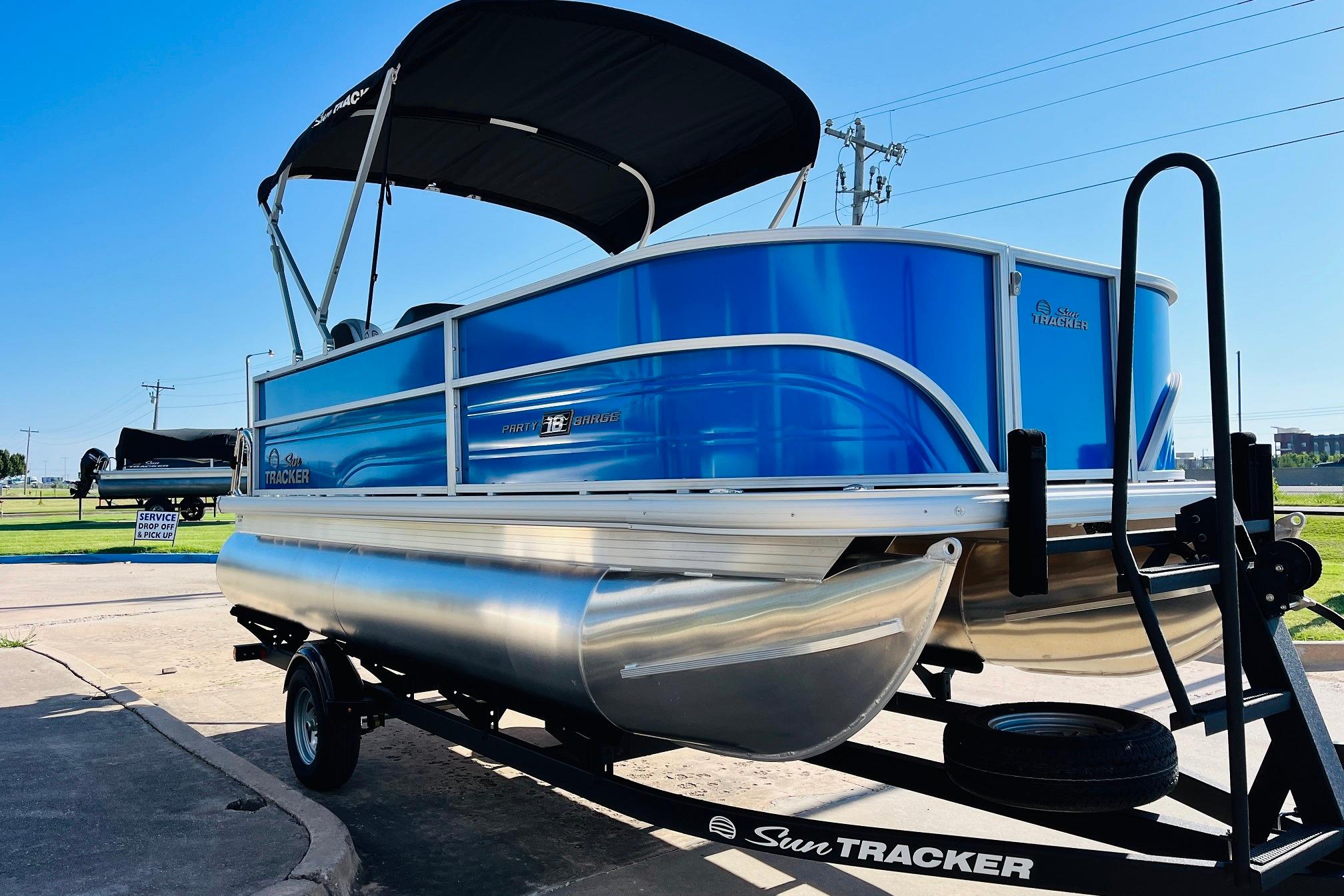 2026 Sun Tracker Party Barge 18 DLX pontoon boat on trailer, blue exterior.