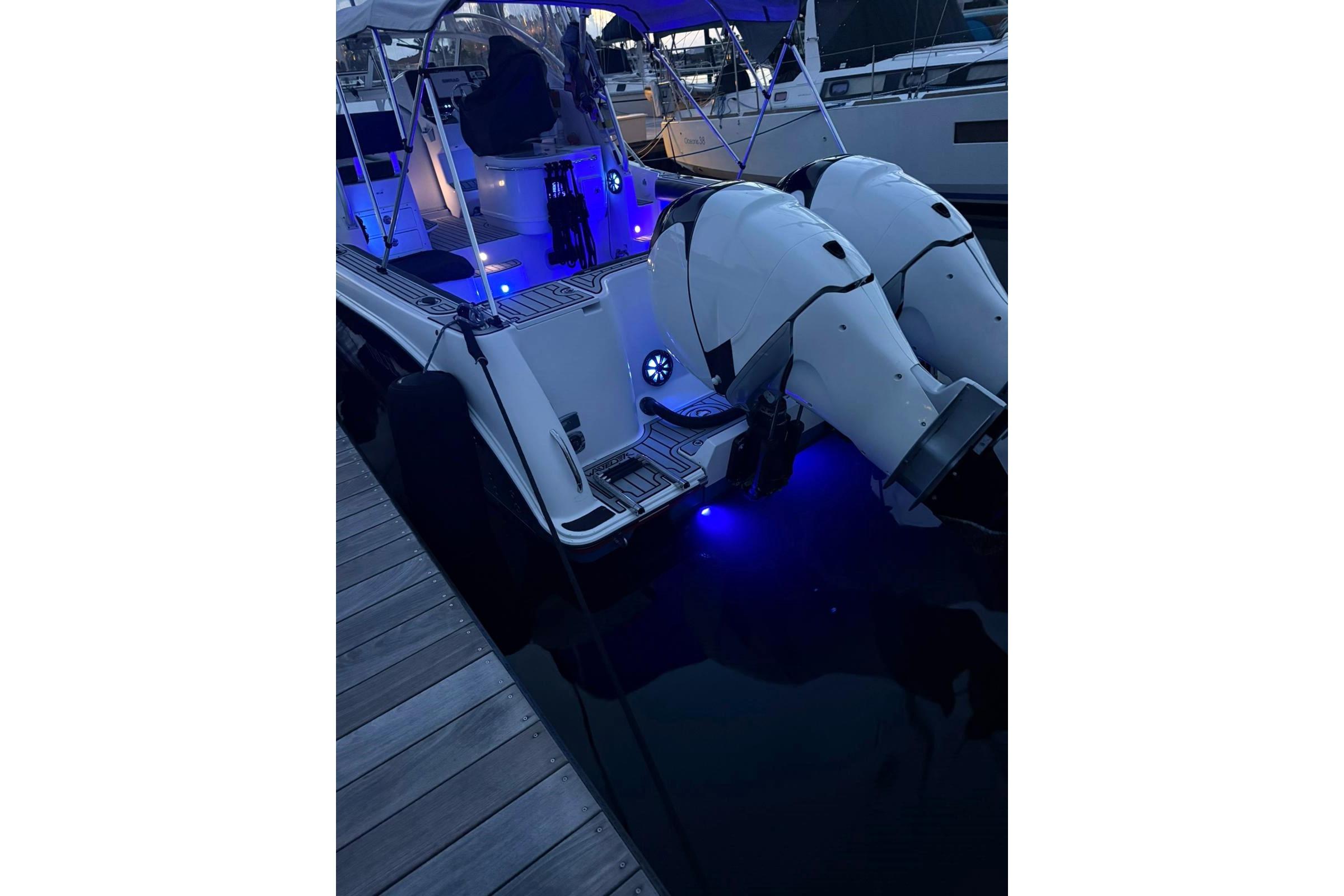2006 Pro-Line 32 Express boat with illuminated deck and dual outboard motors at dock.