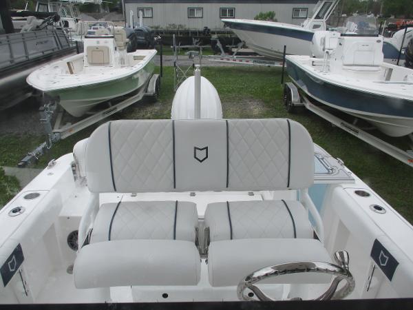 2025 Sea Fox 228 Commander boat interior with white cushioned seating and steering wheel.
