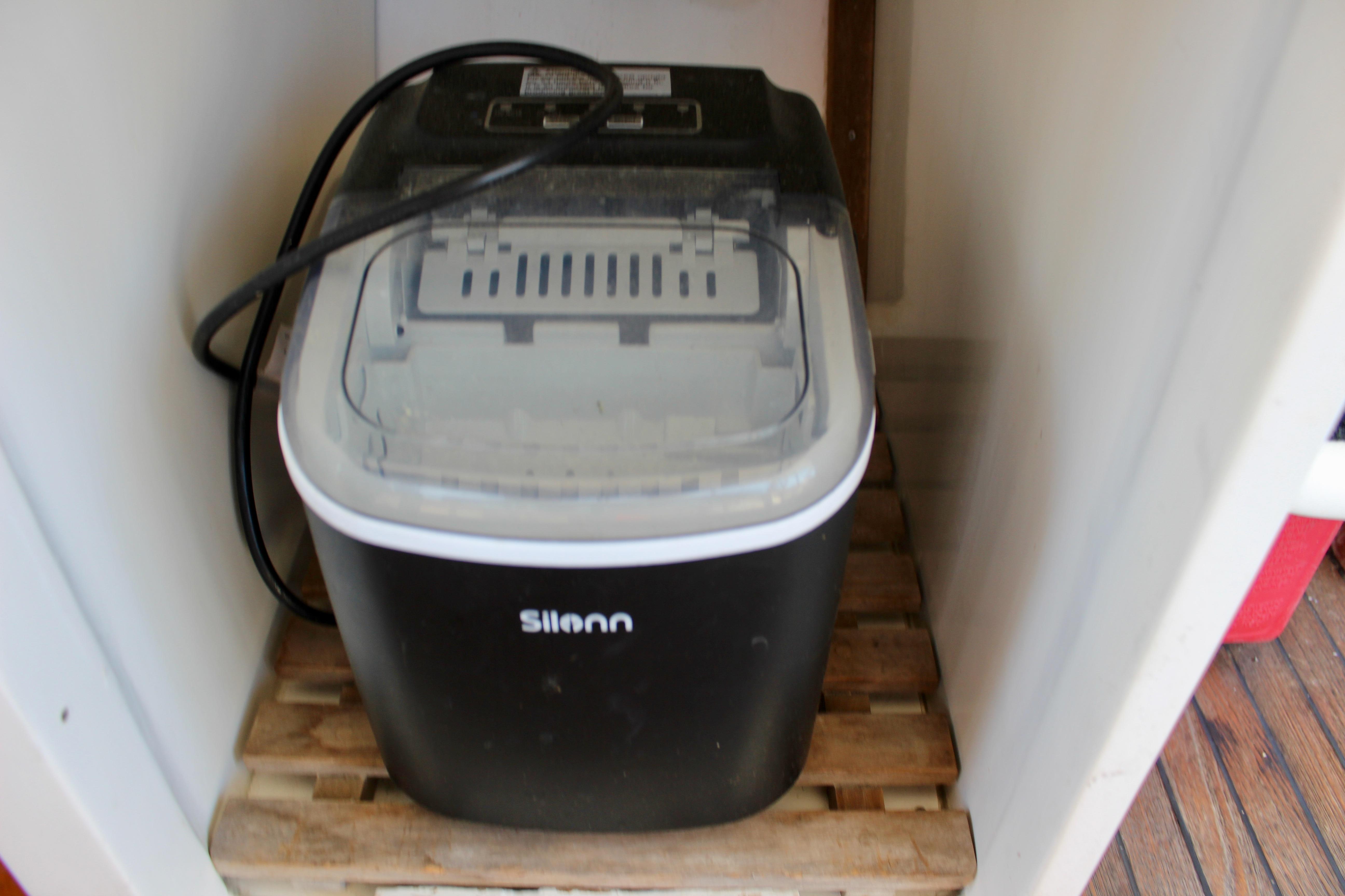 Portable ice maker on a wooden shelf inside a 1986 Kha Shing Spindrift 46 yacht.