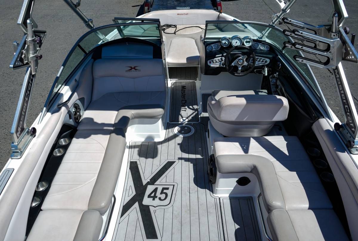 Interior view of a MasterCraft X-45 boat with gray seating and a modern dashboard.