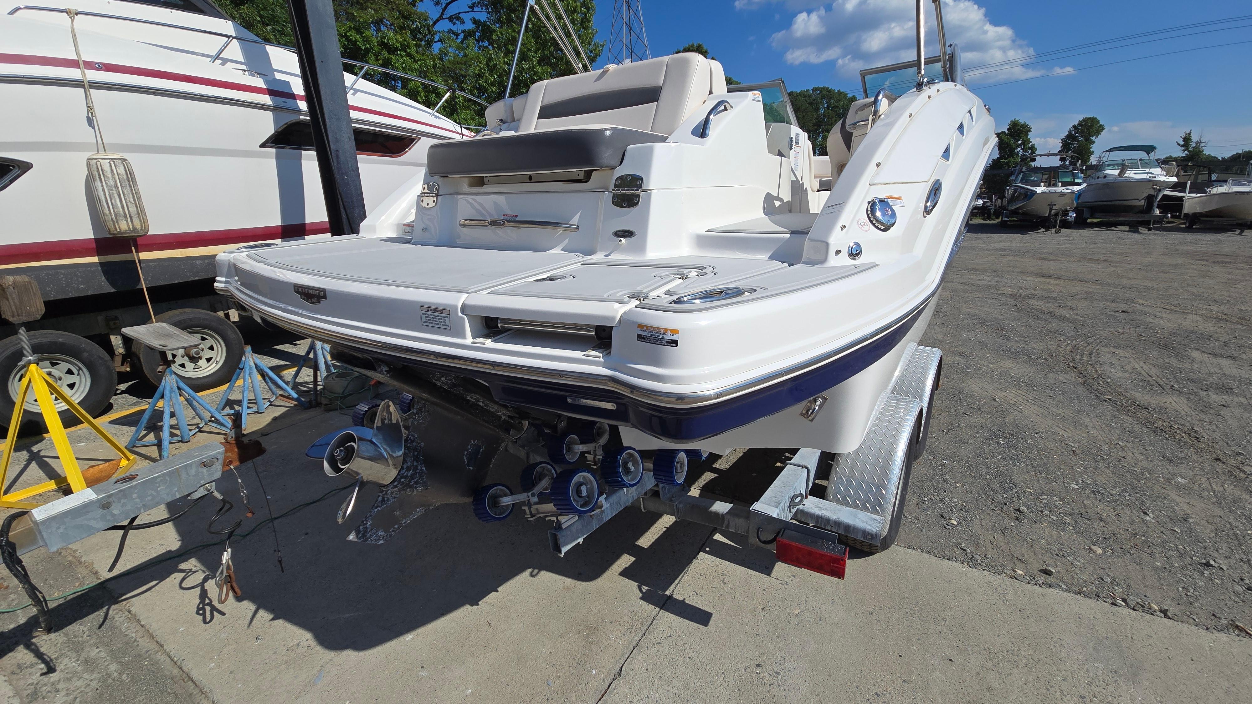 2018 Chaparral 224 Sunesta boat on trailer, rear view, in a marina setting.