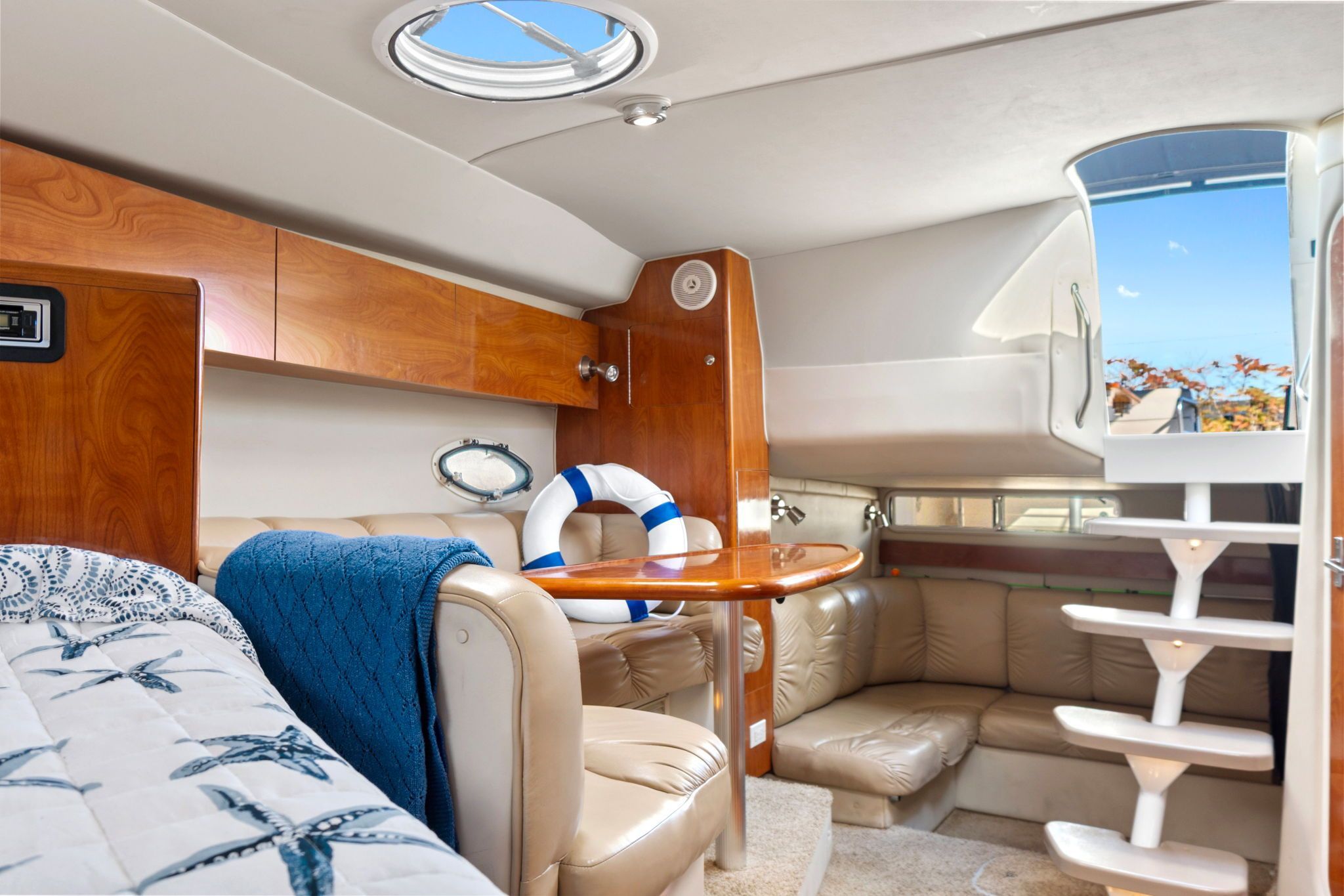 Interior of the 2007 Larson Cabrio 330 with cozy seating area and wooden table.