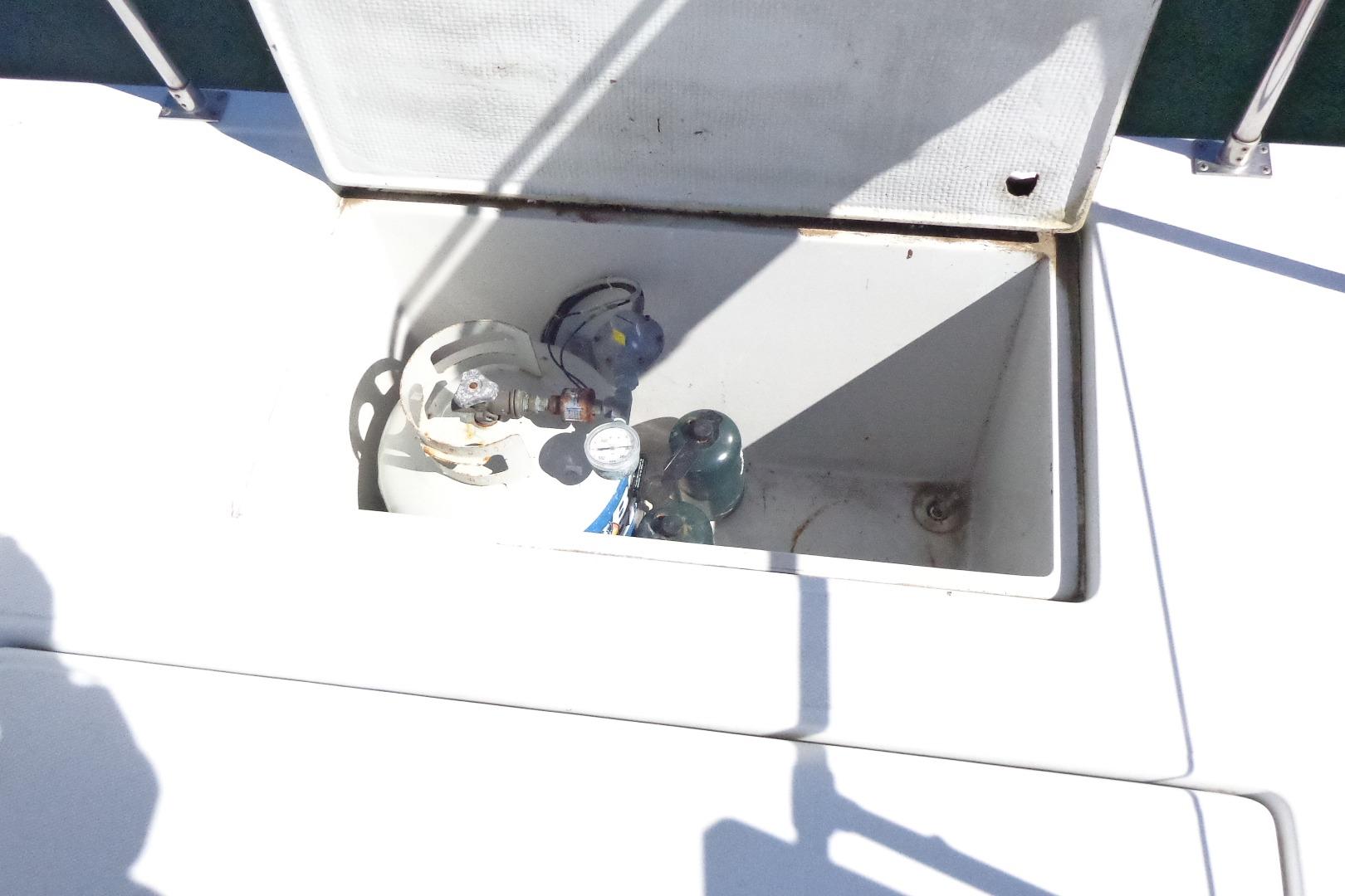 Open storage compartment on 1992 Cruise-A-Home Corsair 4200 boat, containing gas cylinders.