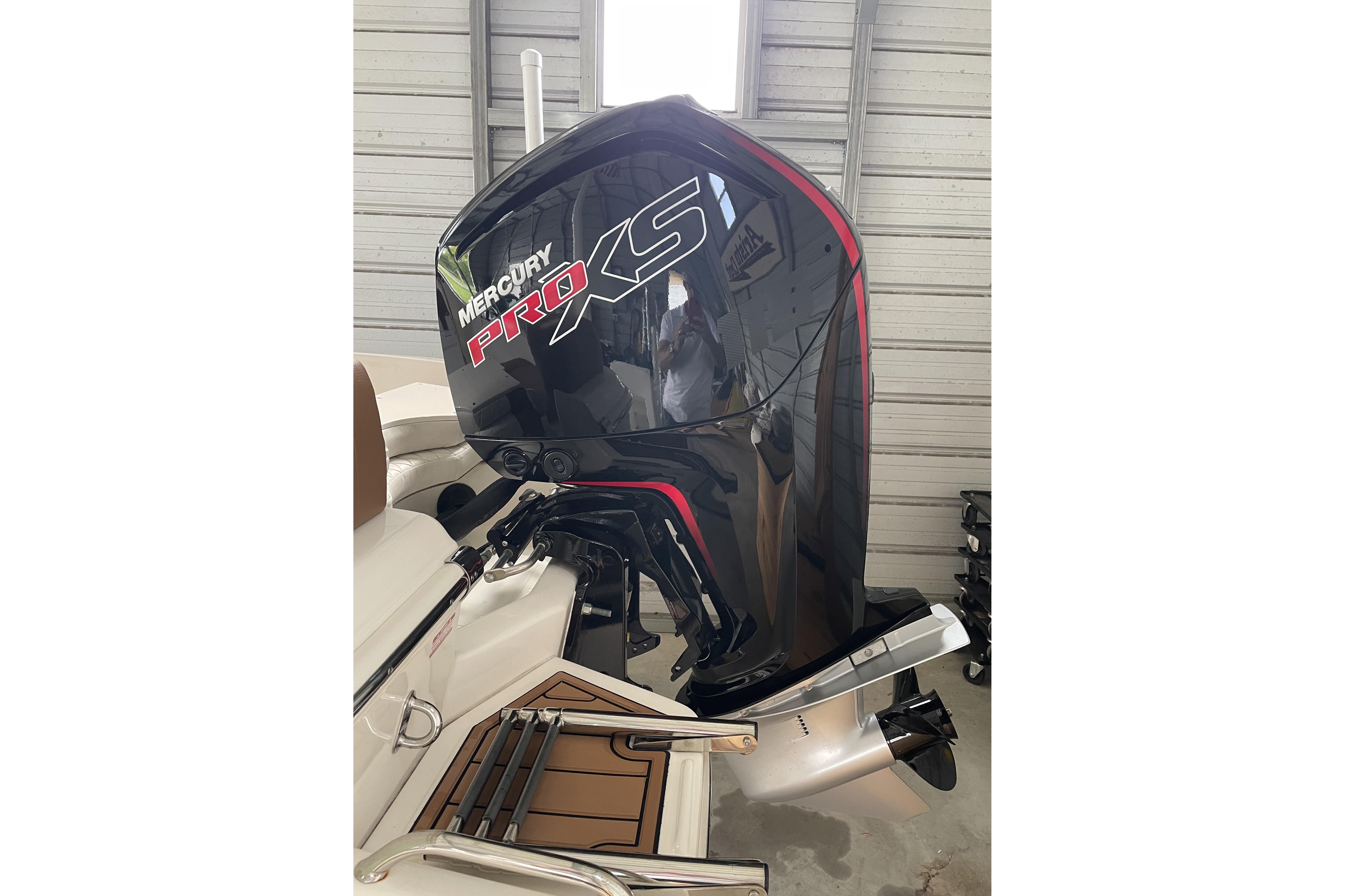 2024 Pioneer 180 Islander with Mercury Pro XS outboard motor in a garage setting.