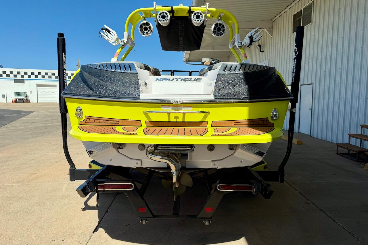 2014 Nautique Super Air Nautique G21 boat, vibrant yellow, rear view in a marina setting.