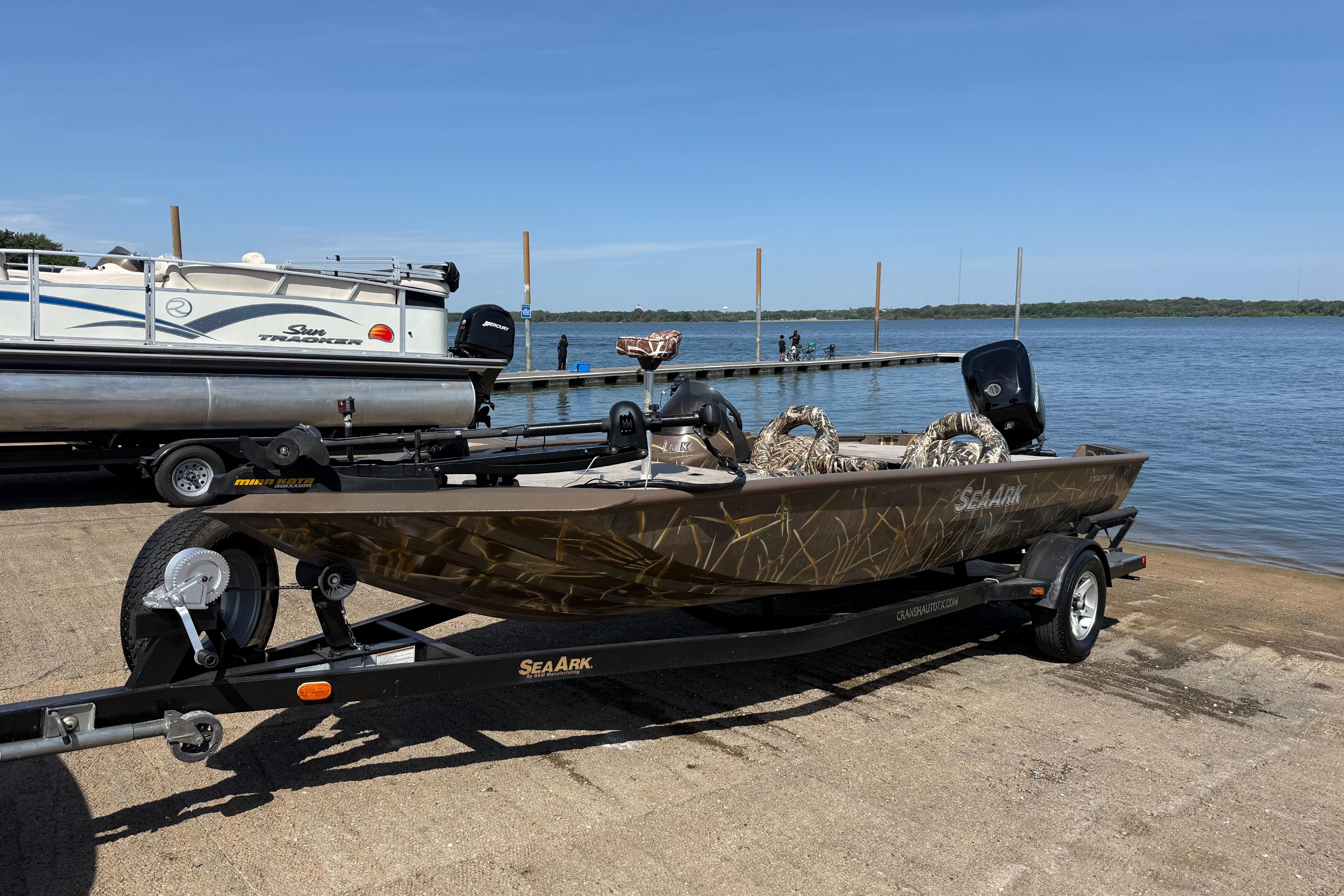 2010 SeaArk Stealth 190 boat on trailer by lake, ready for launch.