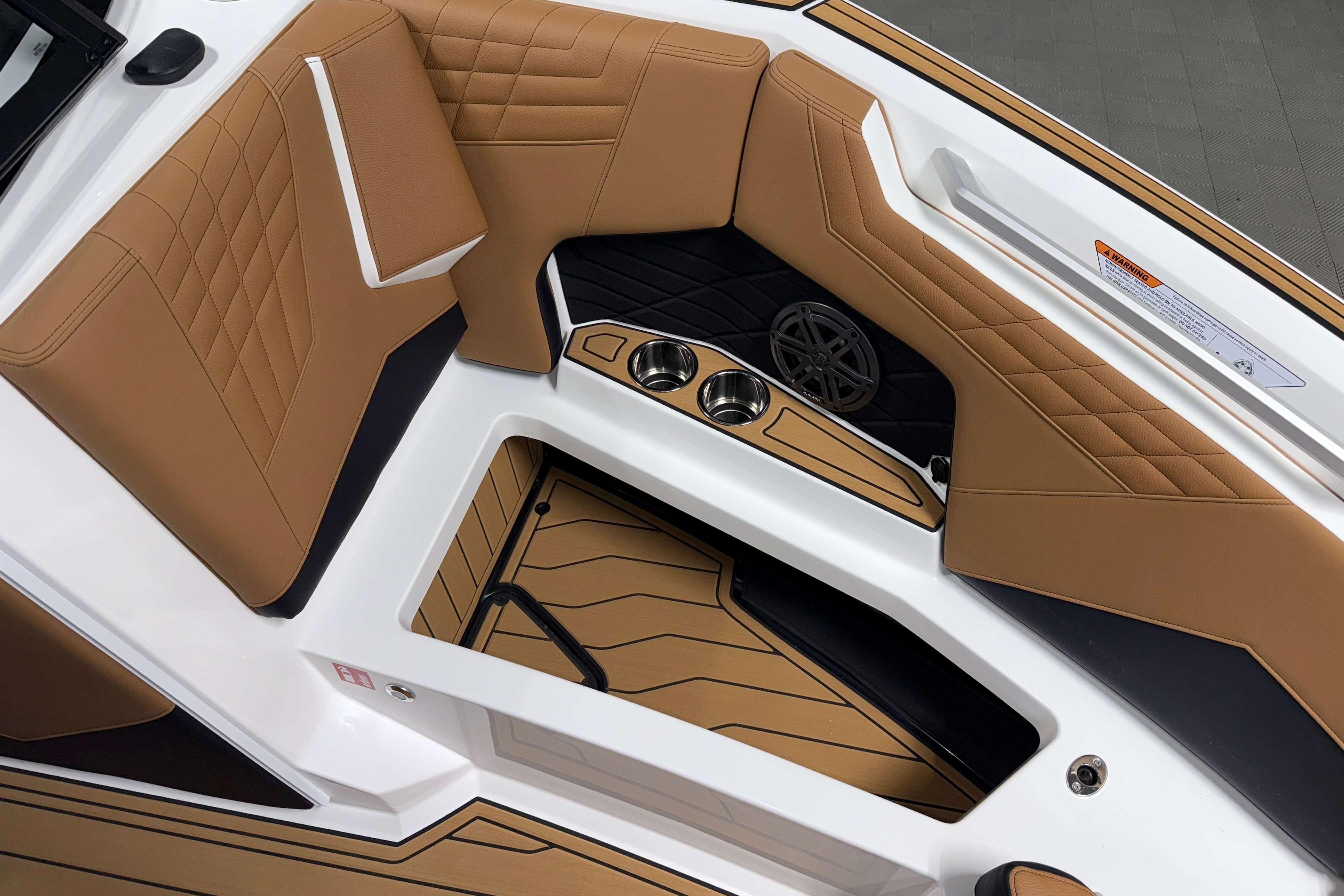 2026 Nautique Super Air Nautique S23 interior with tan upholstery and cup holders.