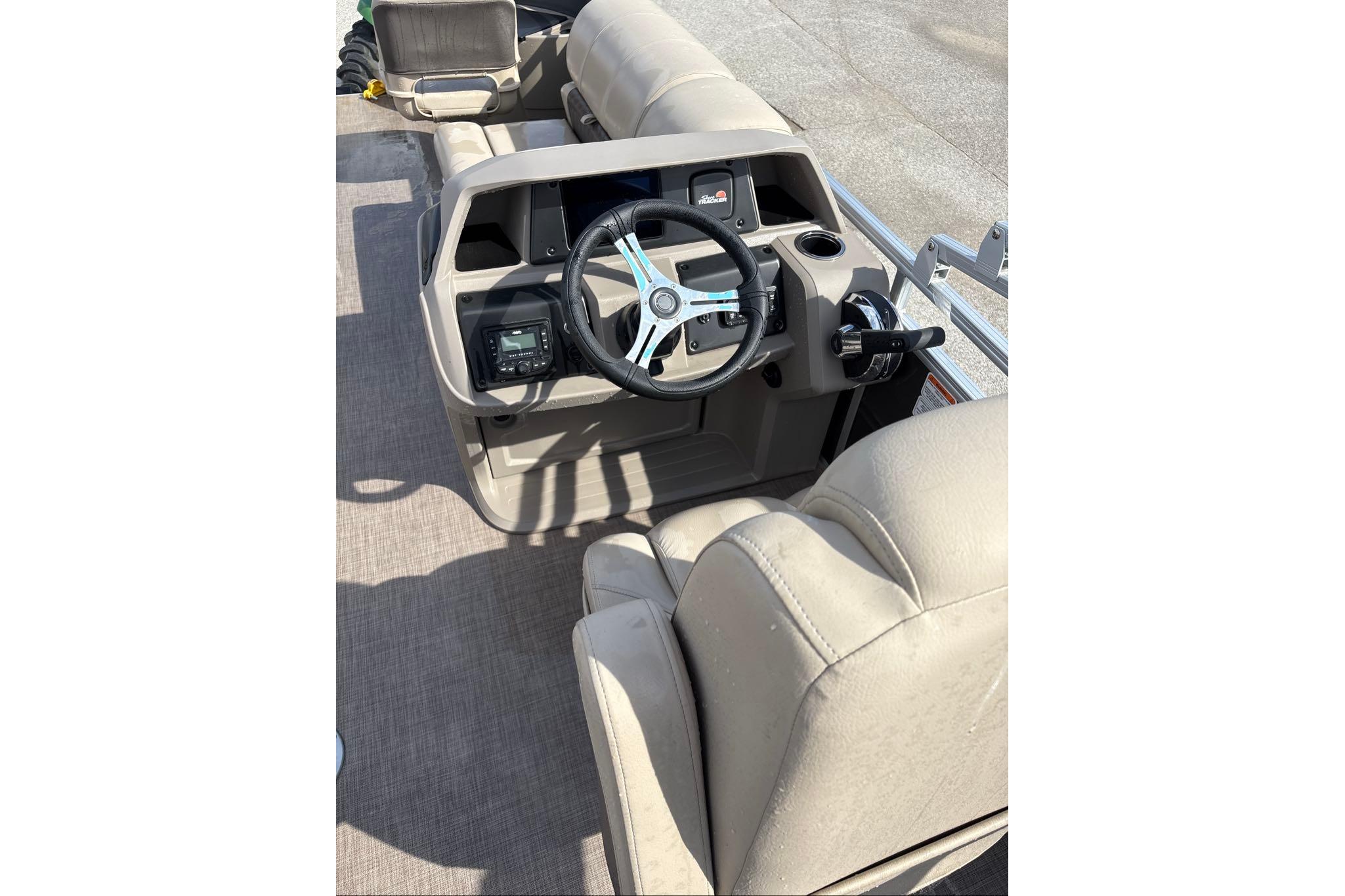 2025 Sun Tracker Fishin' Barge 20 DLX interior with steering wheel and seating.