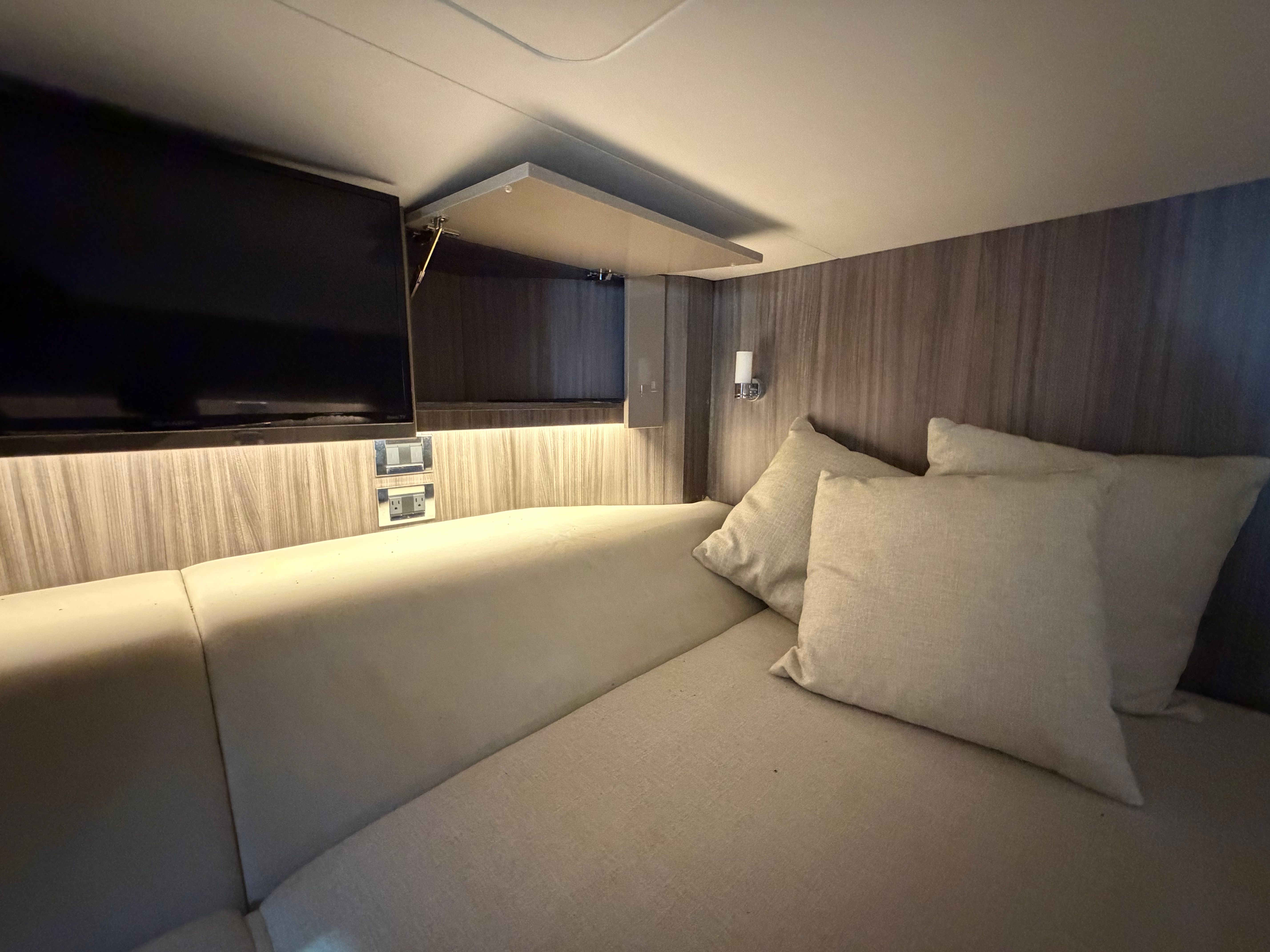 Interior of 2020 Sea Ray SLX 400 Outboard with TV and cushions.