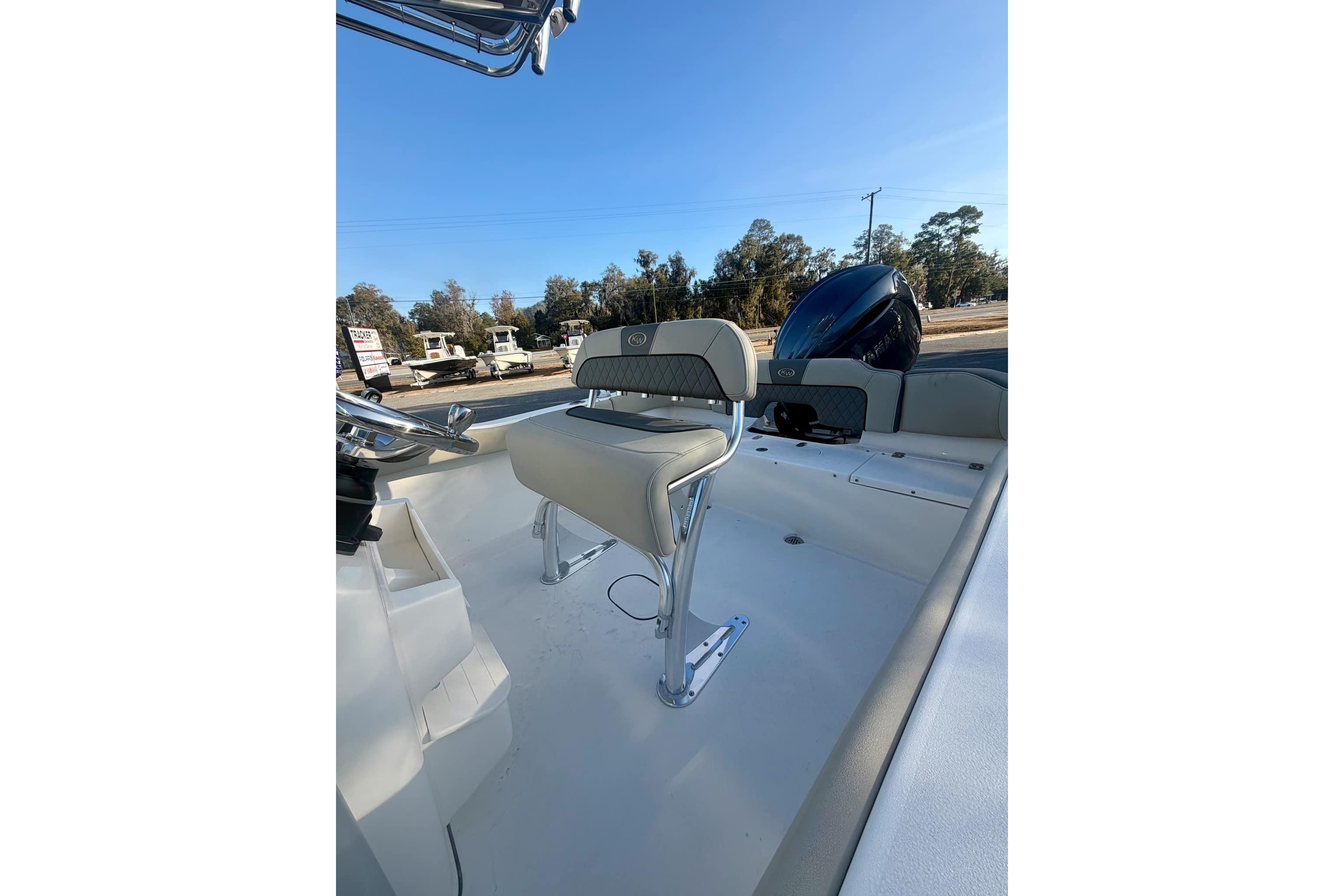 2026 Key West 203 FS boat interior with seating and motor, under clear blue sky.