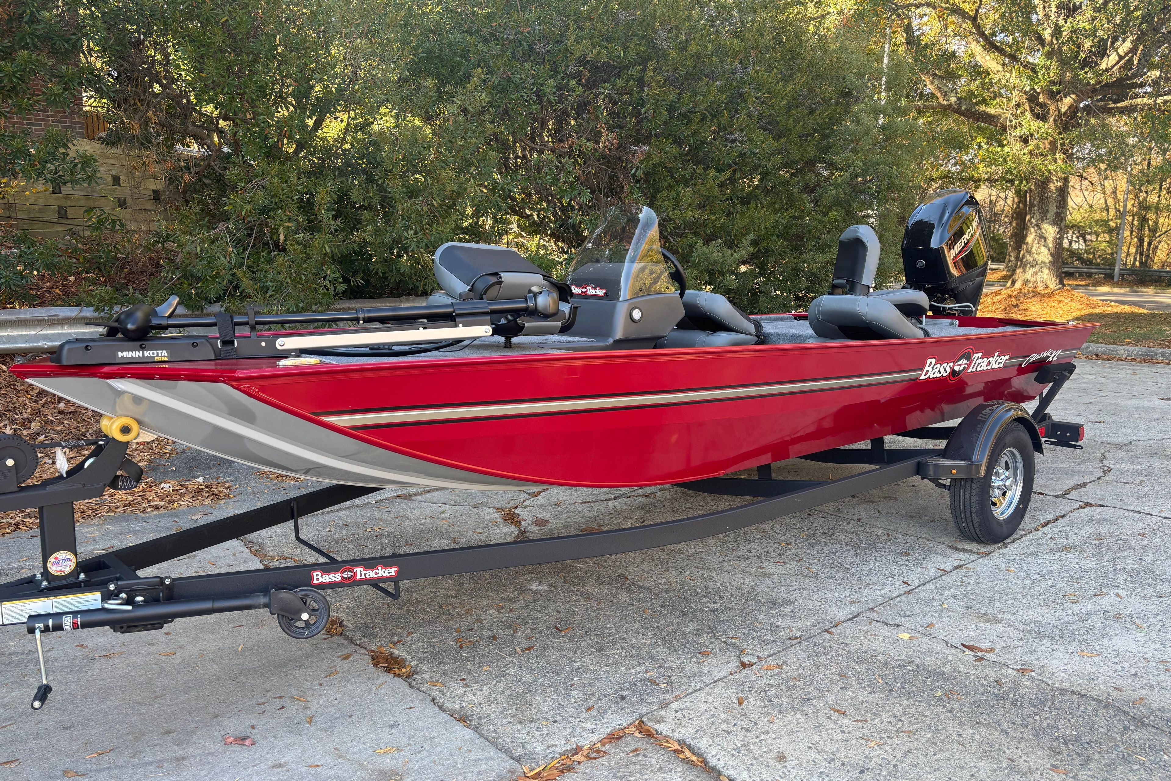 2026 Tracker Bass Tracker Classic XL boat on trailer, red exterior, parked outdoors.