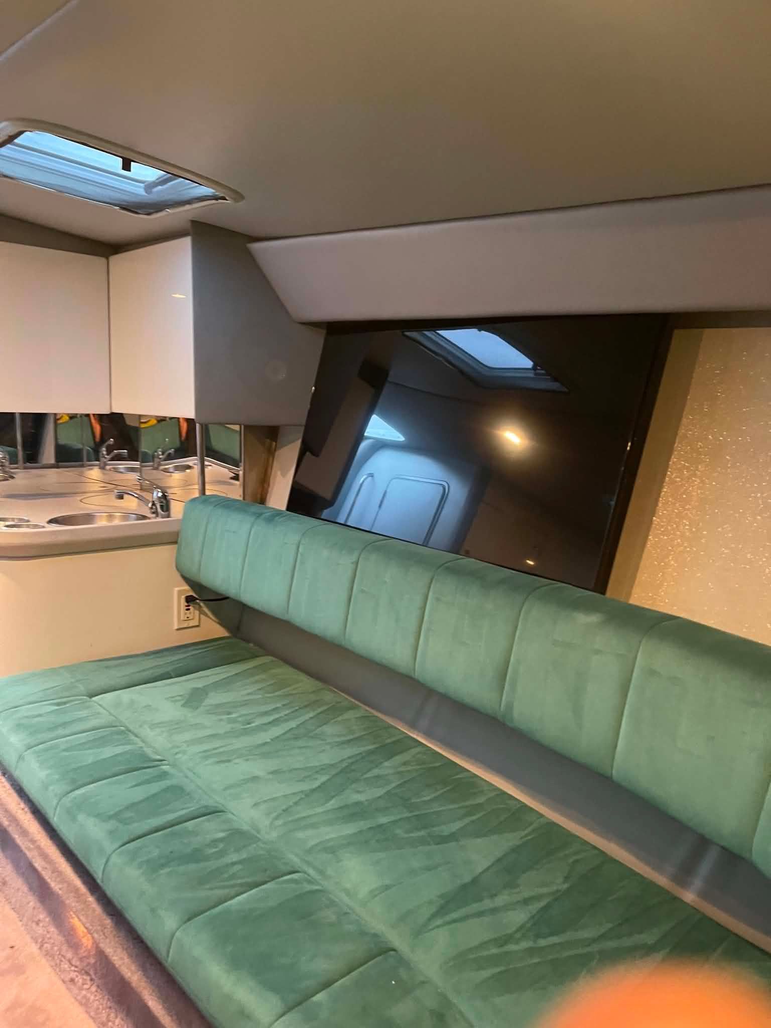 Interior of a 2000 Formula 419 Fast Tech with green sofa and kitchenette.