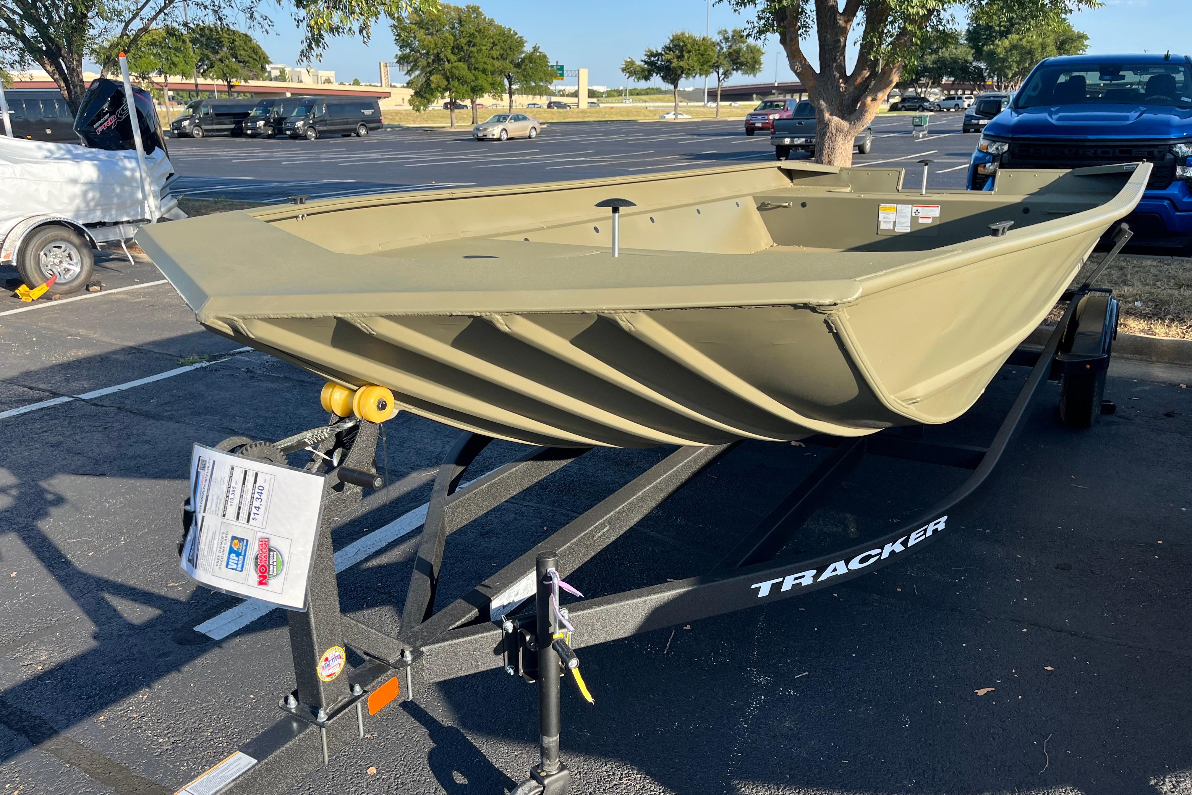 2026 Tracker GRIZZLY 2072 Utility boat on trailer in parking lot.