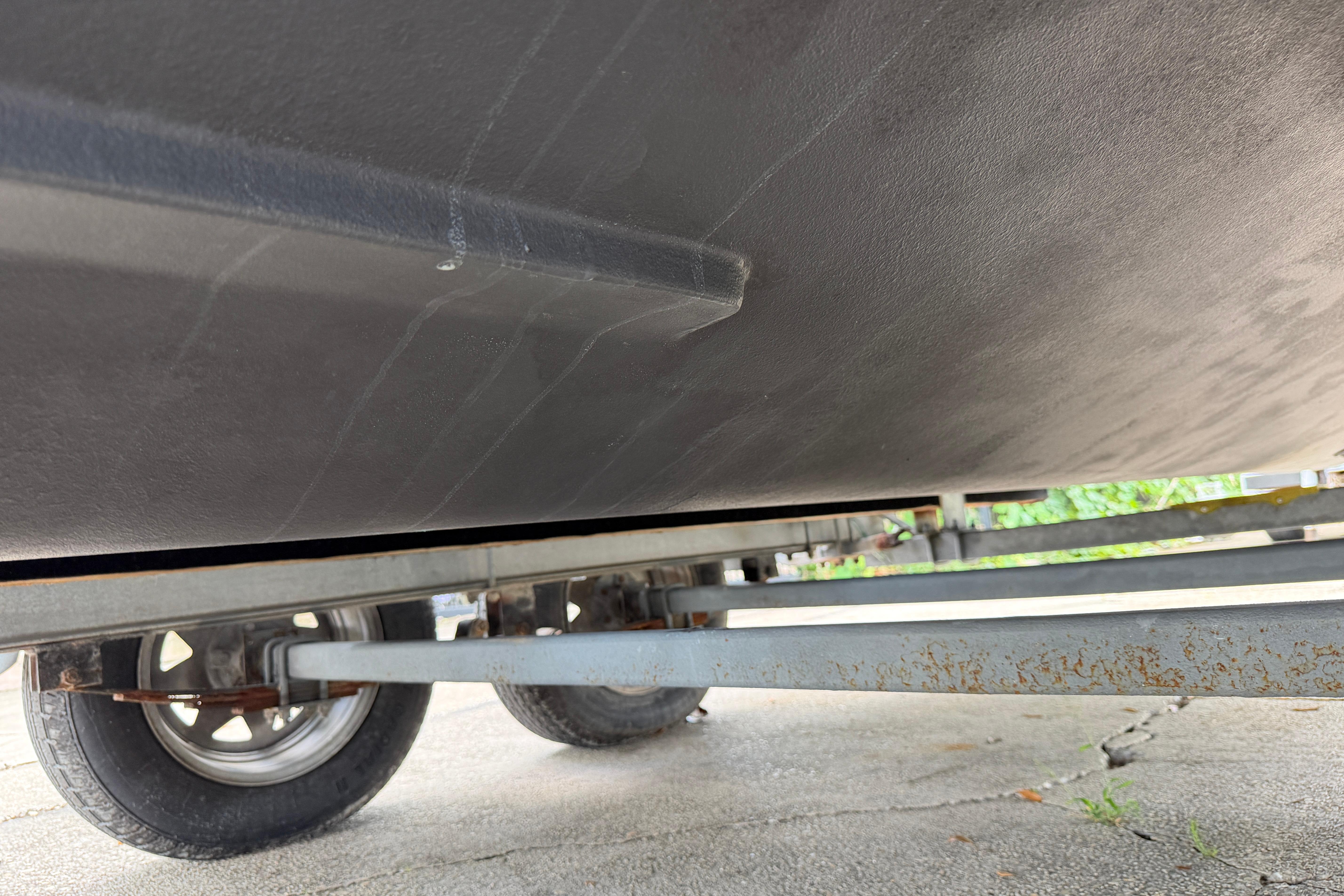 1987 Grady-White Seafarer 226 boat hull on trailer, showcasing underside and wheels.