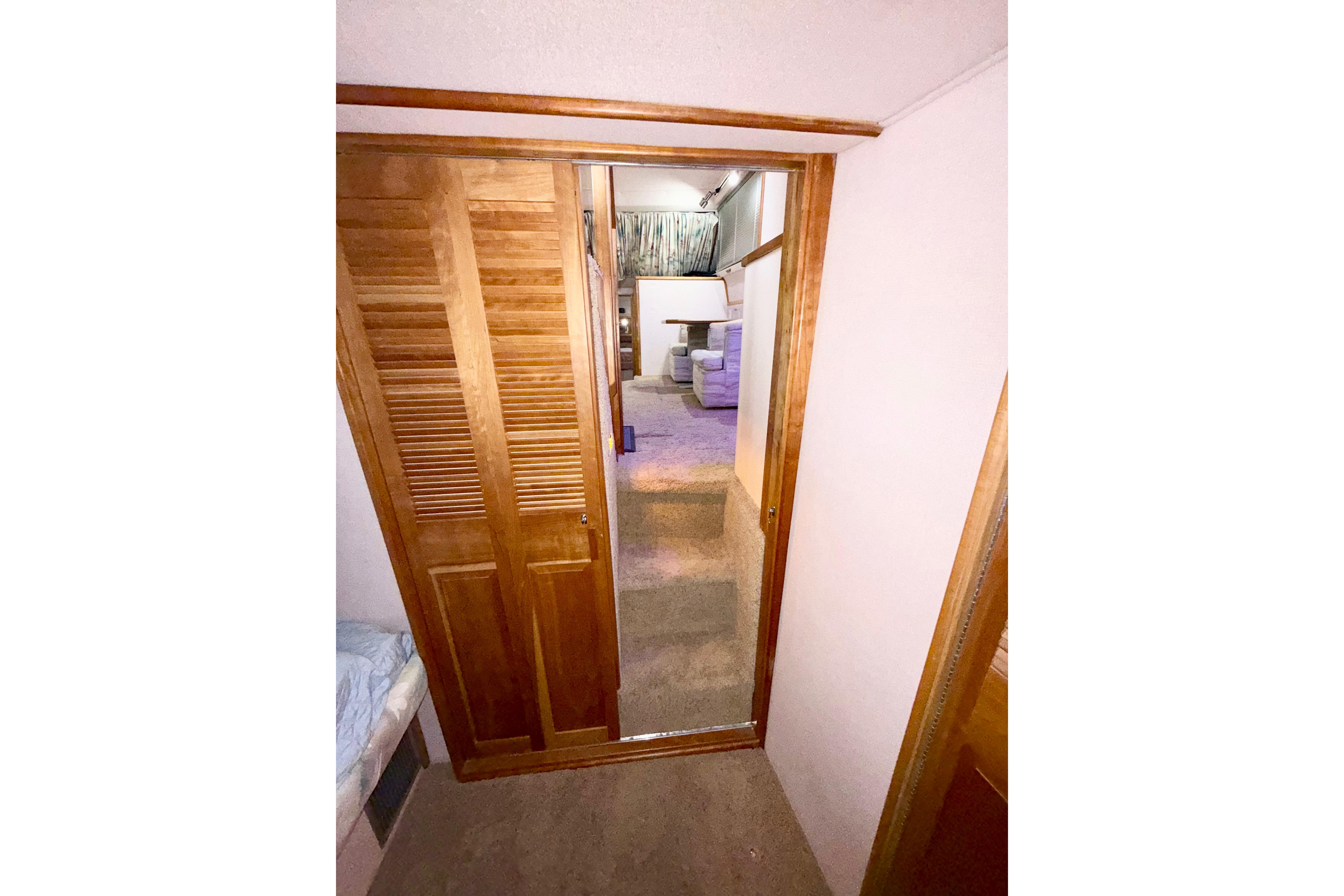 Interior view of 1989 Sea Ray 380 Aft Cabin with wooden closet and carpeted floor.