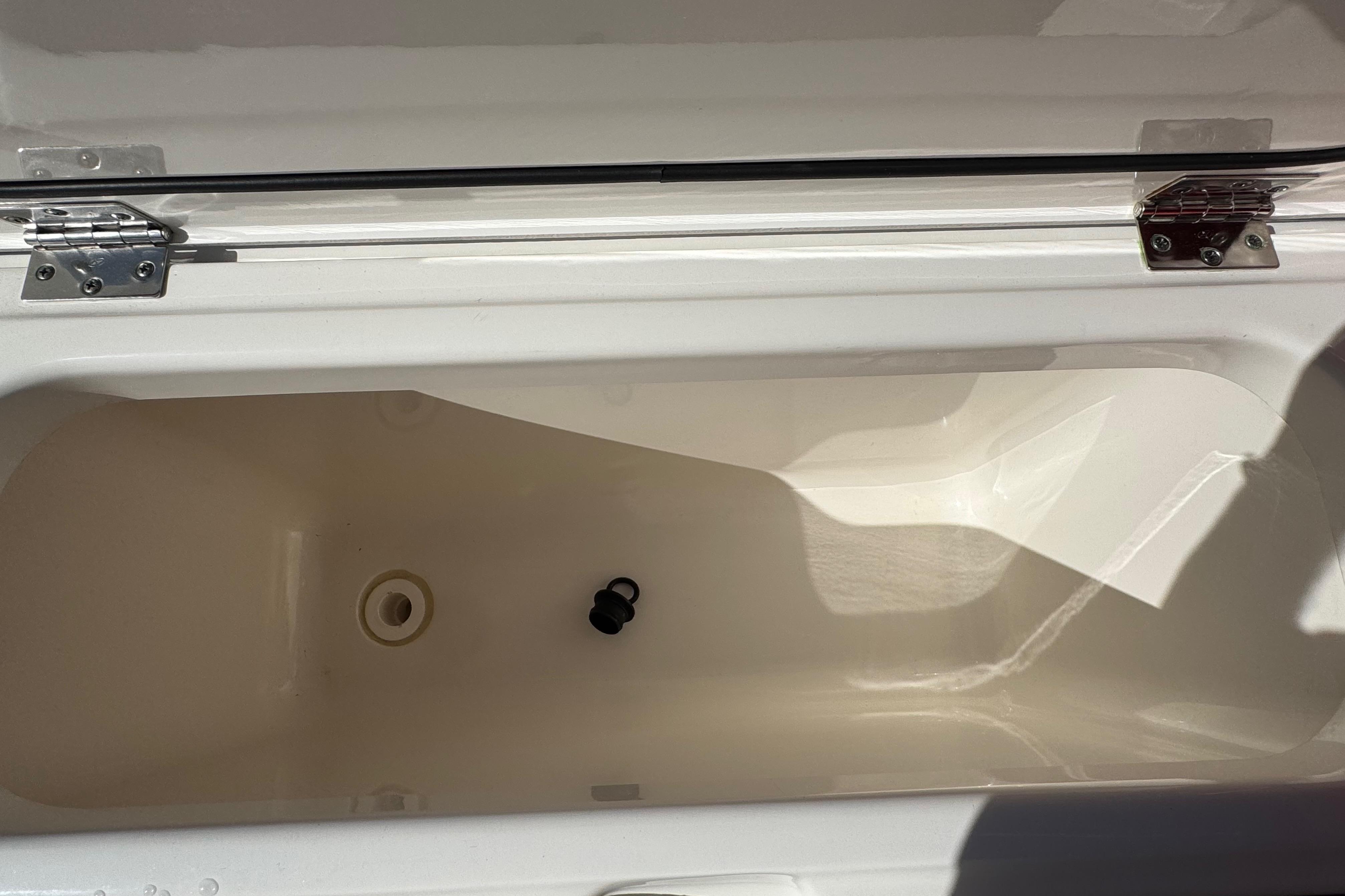 Open storage compartment of 2022 Pursuit DC 266 Dual Console boat.