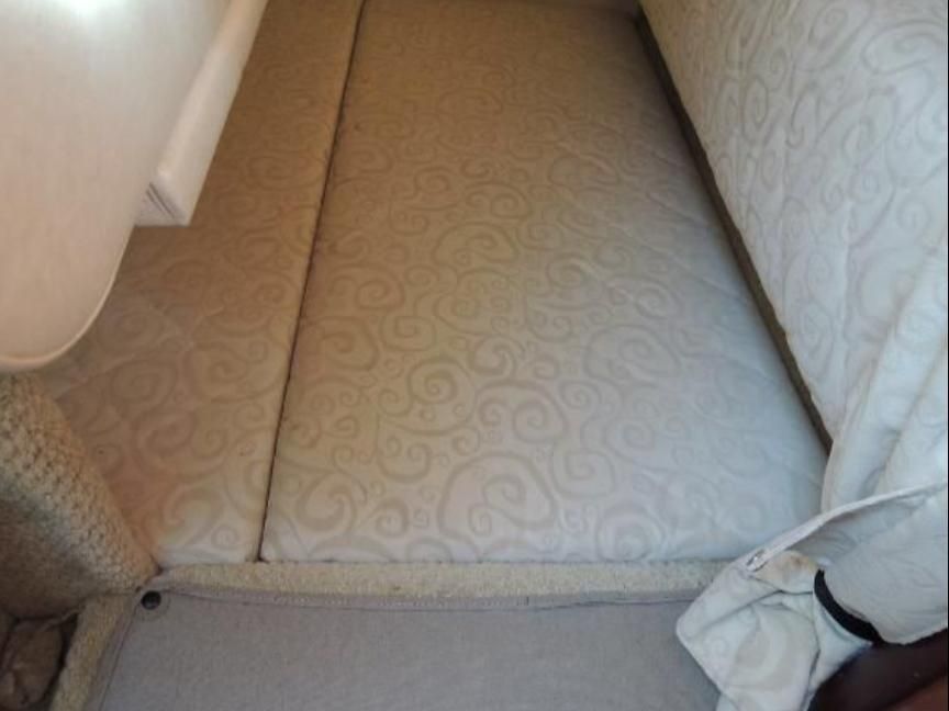 Interior of 2005 Sea Ray Sundancer 260 with cushioned bed.