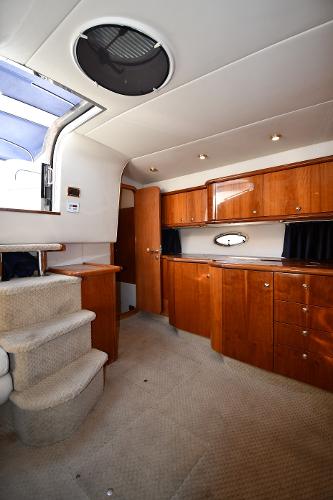 Interior of 1997 Sunseeker Camargue 47 yacht with wooden cabinetry and carpeted stairs.