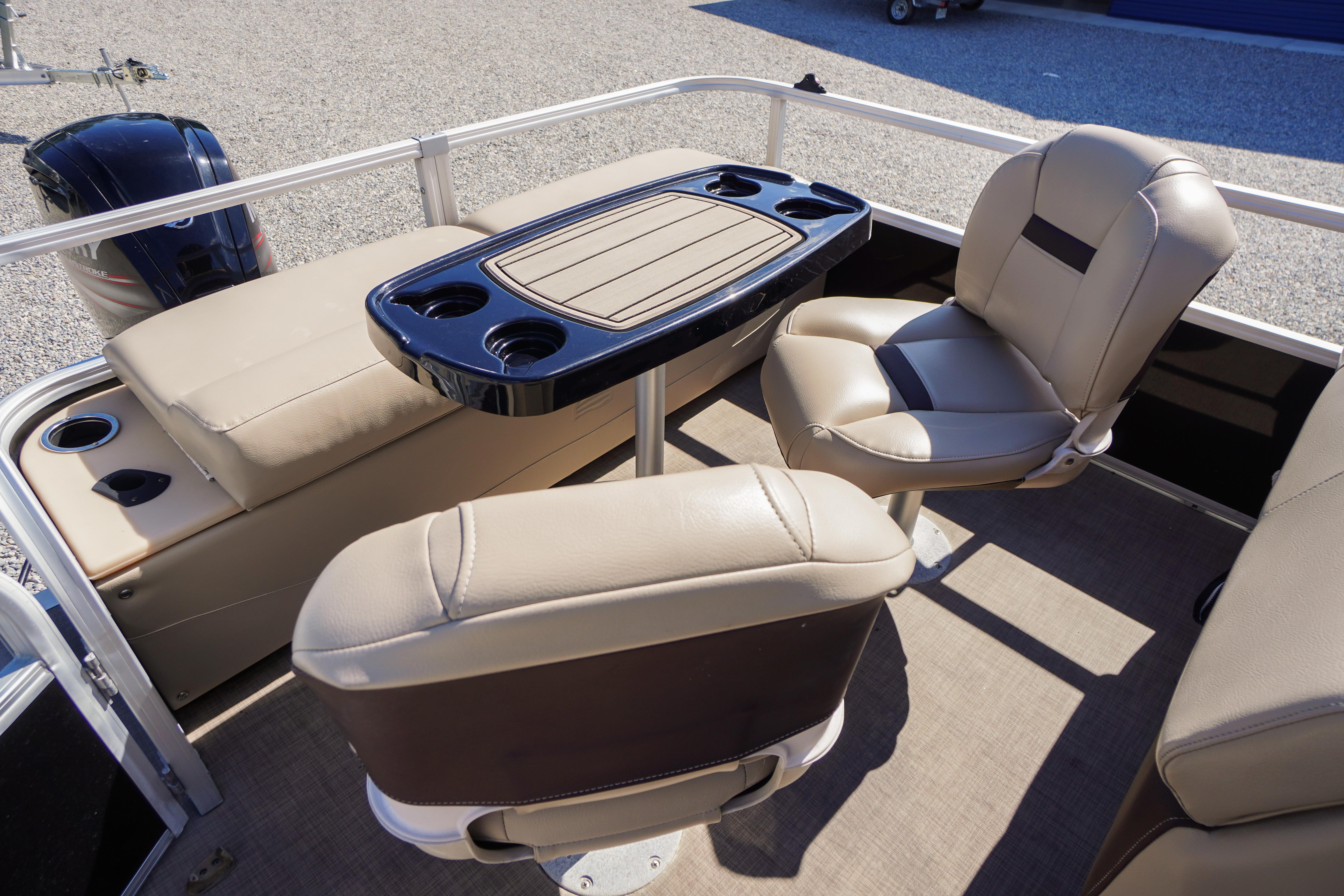 2019 SUNTRACKER Fishin' Barge 22 DLX interior with beige seating and table.