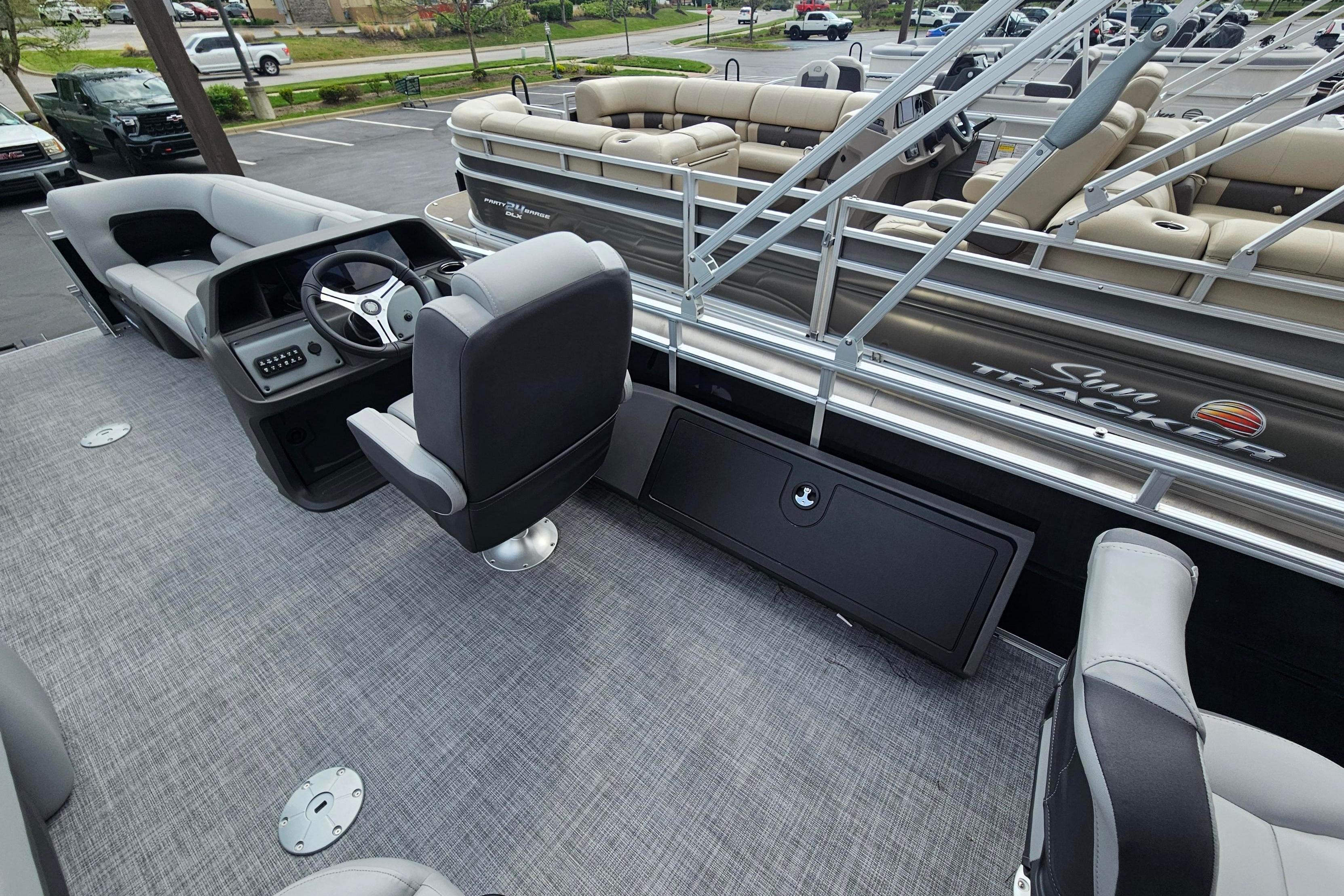 2026 Sun Tracker SportFish 22 DLX pontoon boat interior with steering console and seating.