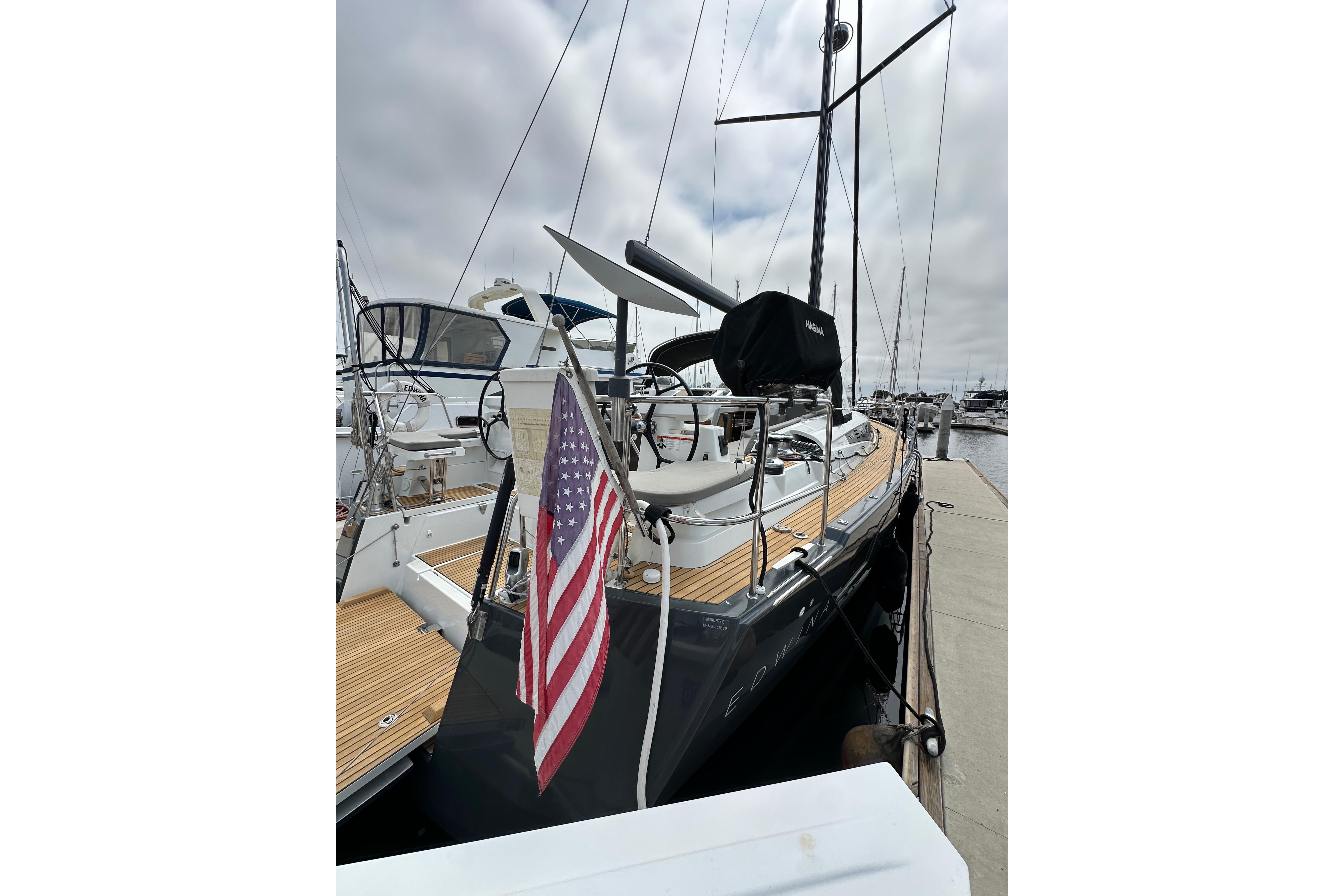 2018 Jeanneau 54 yacht docked with American flag, showcasing sleek design and spacious deck.