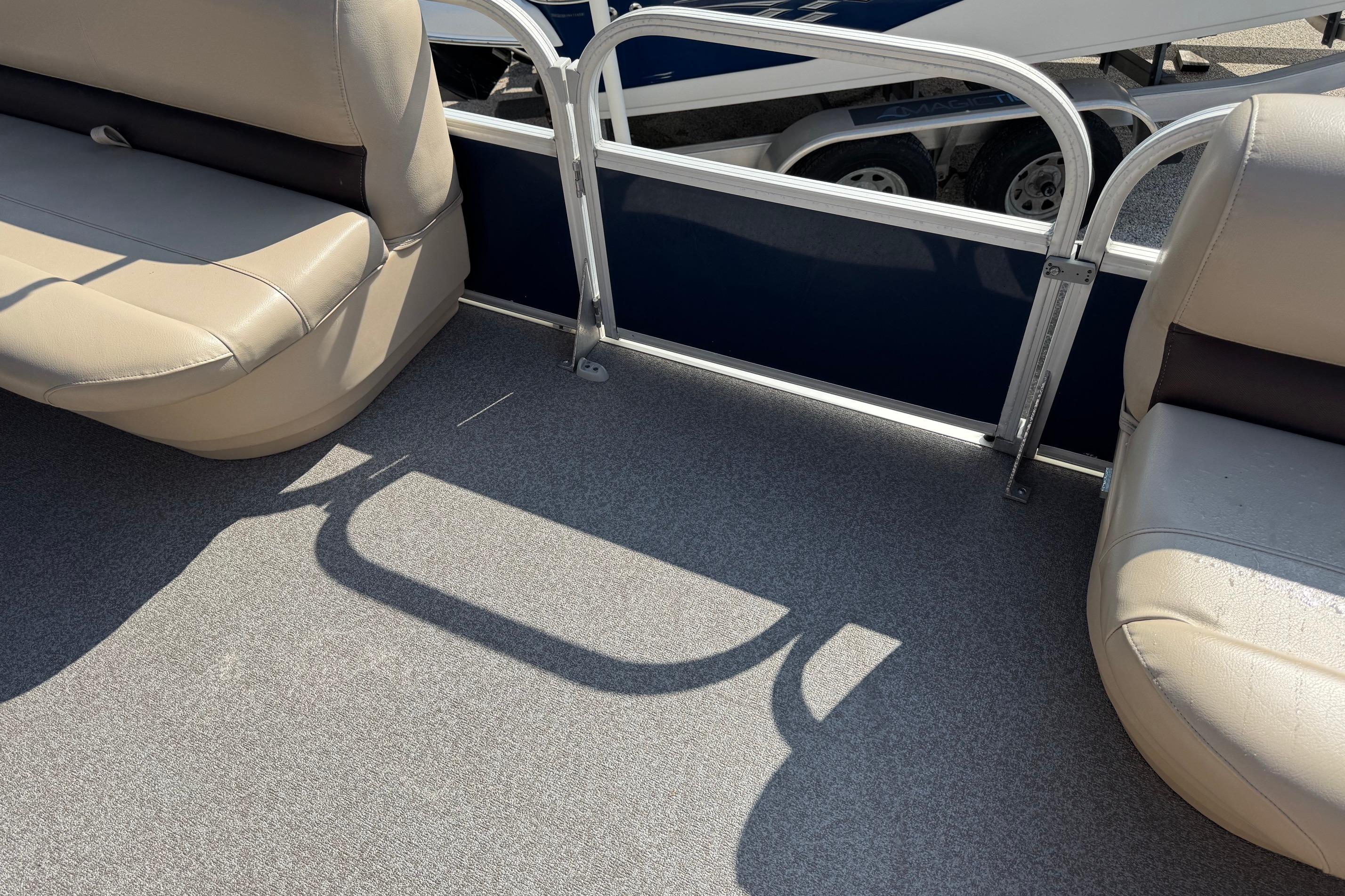 2019 Sun Tracker Party Barge 18 DLX interior with beige seating and gray flooring.