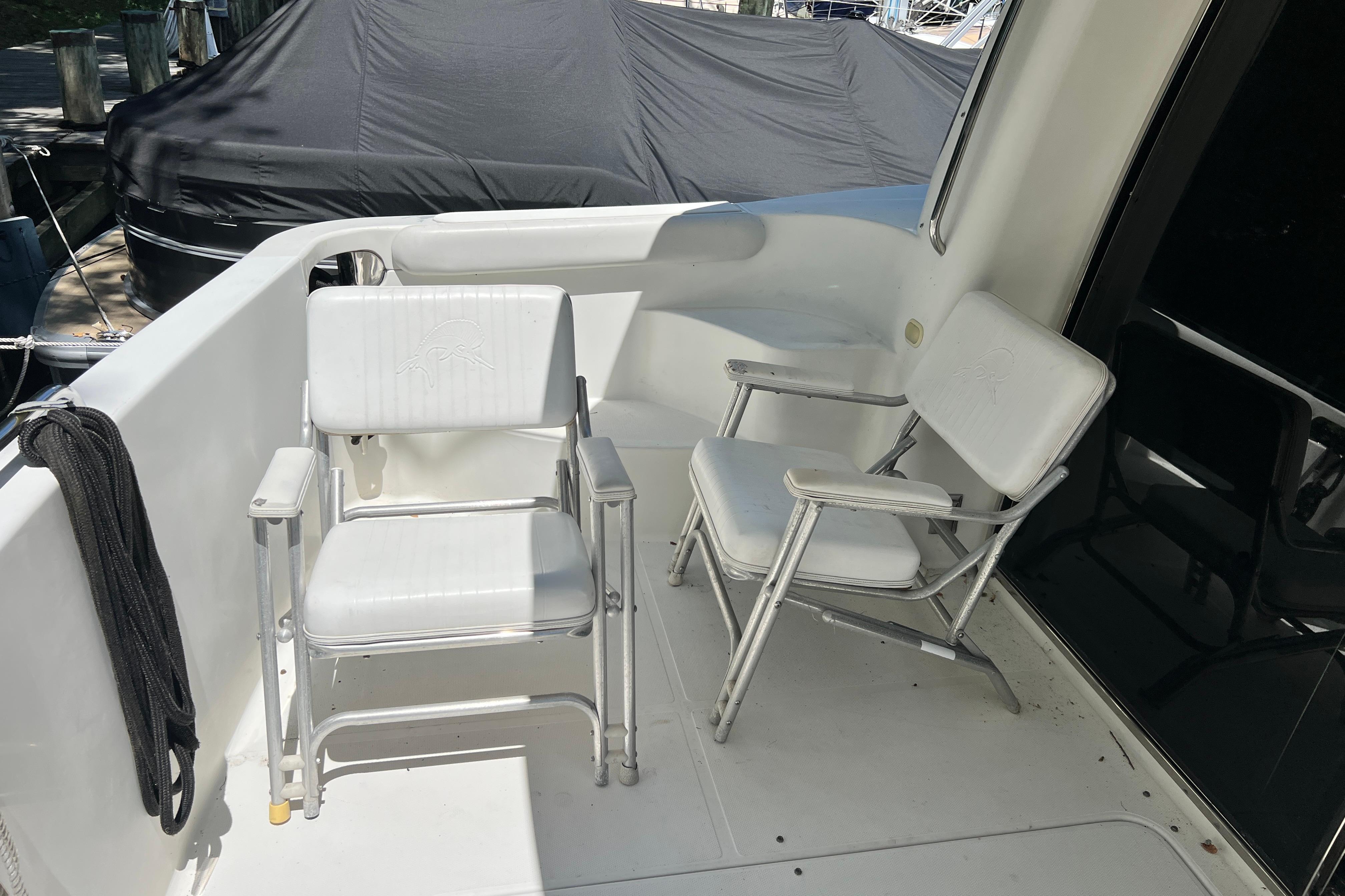 2003 Carver 450 Voyager Pilothouse deck with two white chairs.