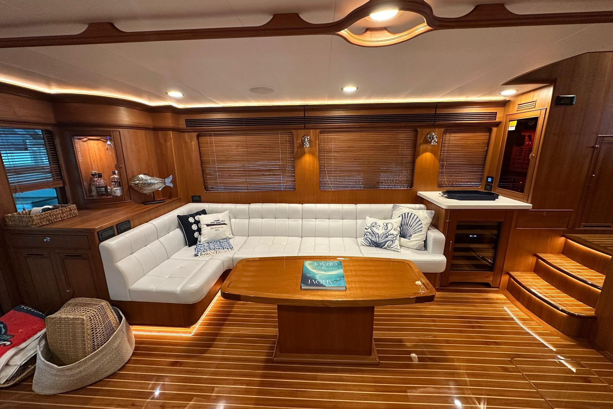 Luxurious interior of 2023 Marlow Explorer 66E-CB yacht with elegant wood finish and plush seating.