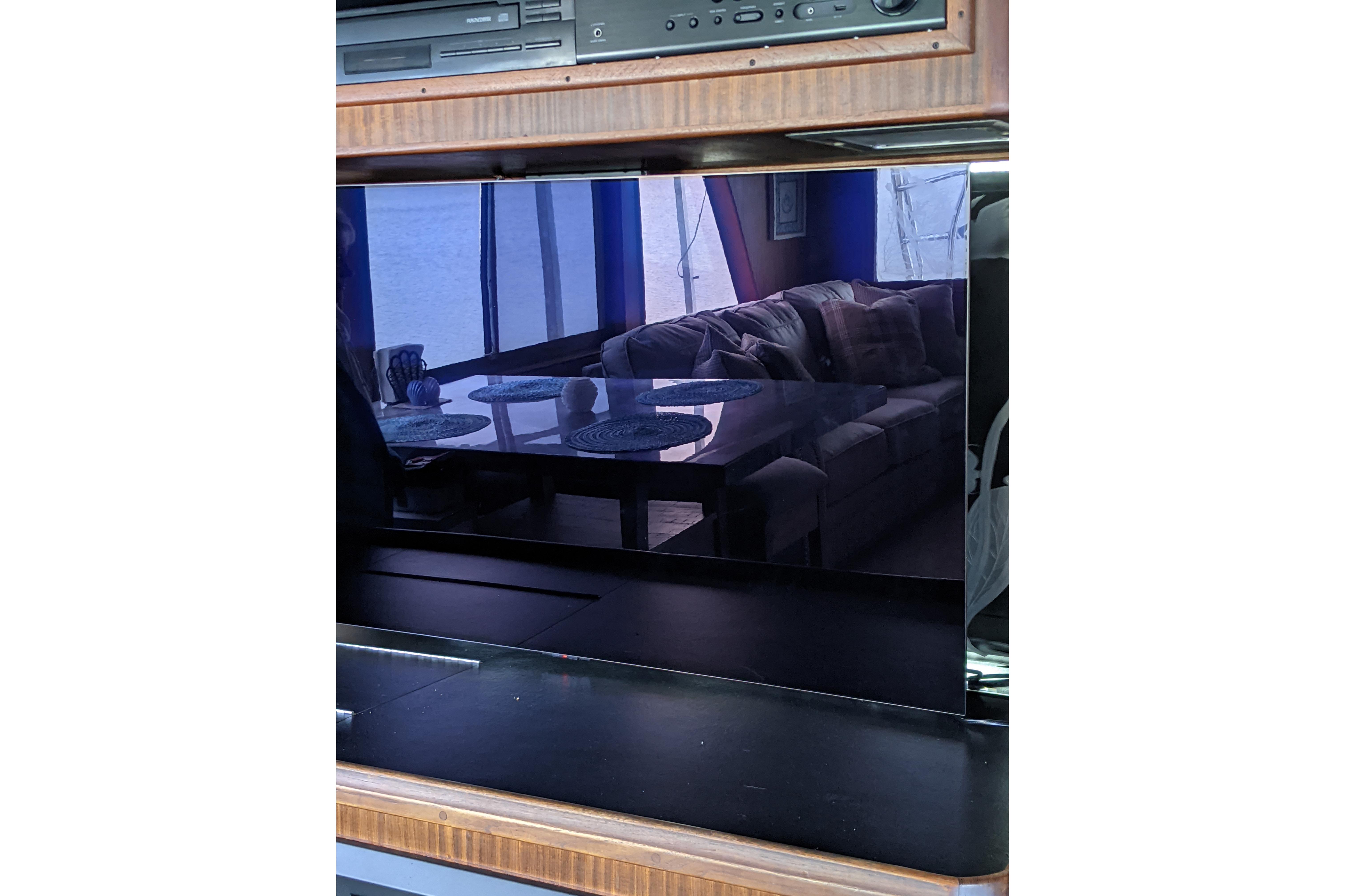 Interior of 1984 Hatteras 53 Yacht, featuring a reflective TV screen and cozy seating area.