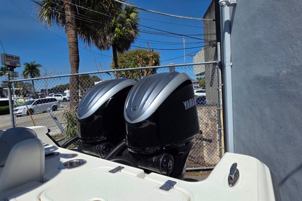 2024 Blackwood 290 boat with dual Yamaha outboard engines, parked near a fence.