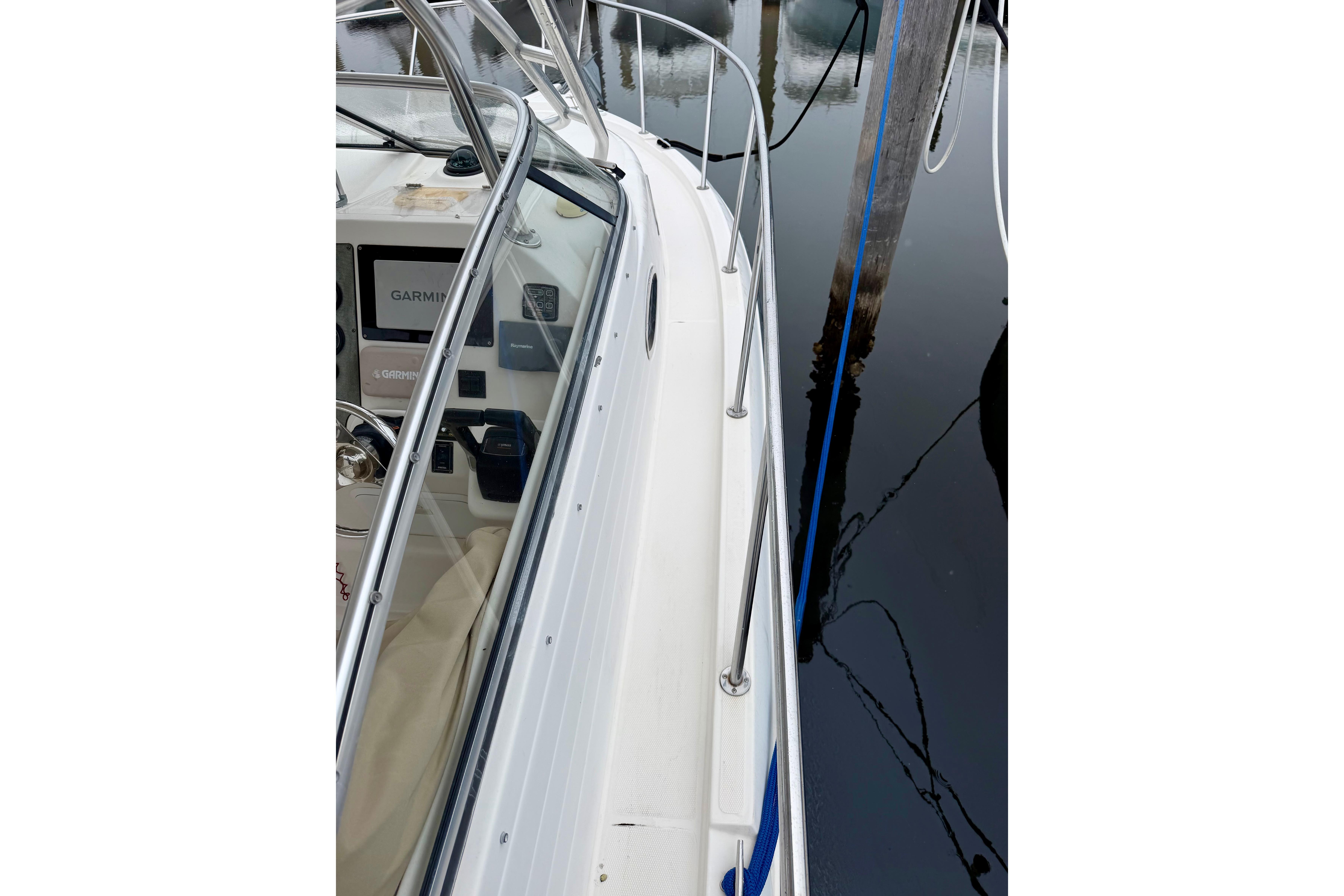 2006 Seaswirl Striper 2901 Walkaround O/B boat docked, showing side railing and cockpit.