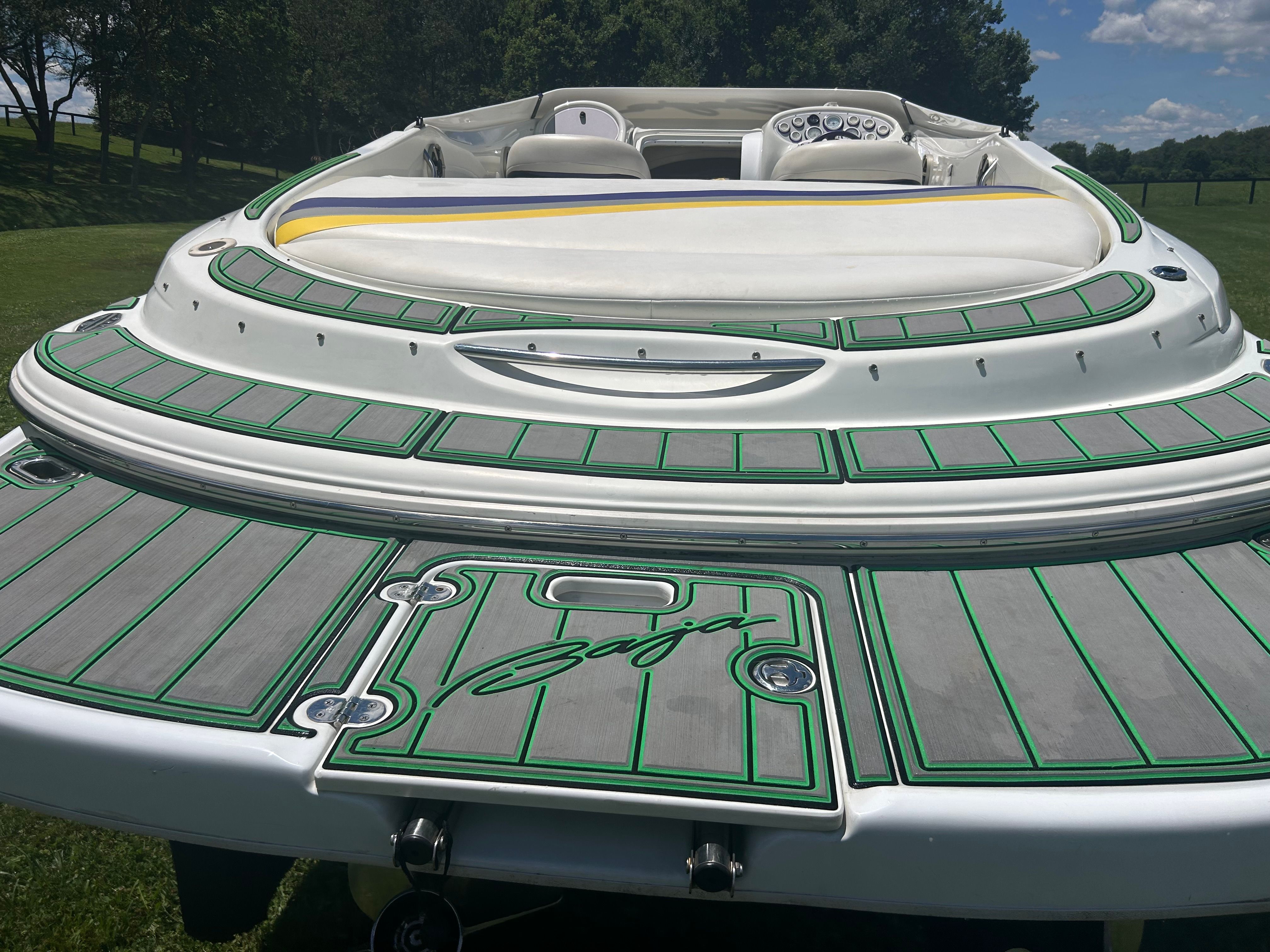 The image shows the stern of a 1996 Baja 302 boat with green deck lining.