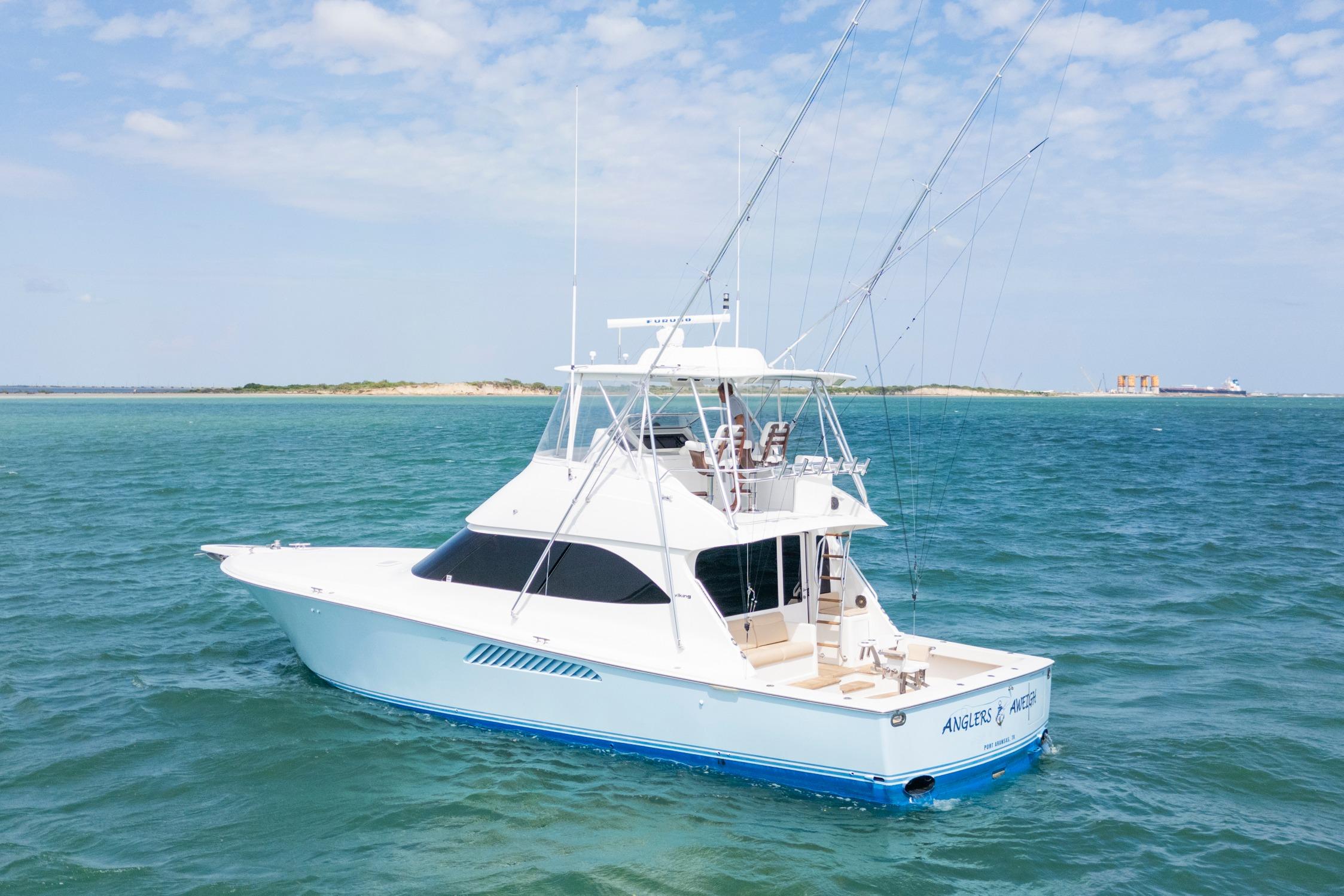 2009 Viking 50 Convertible yacht on open water, clear sky, distant shoreline.