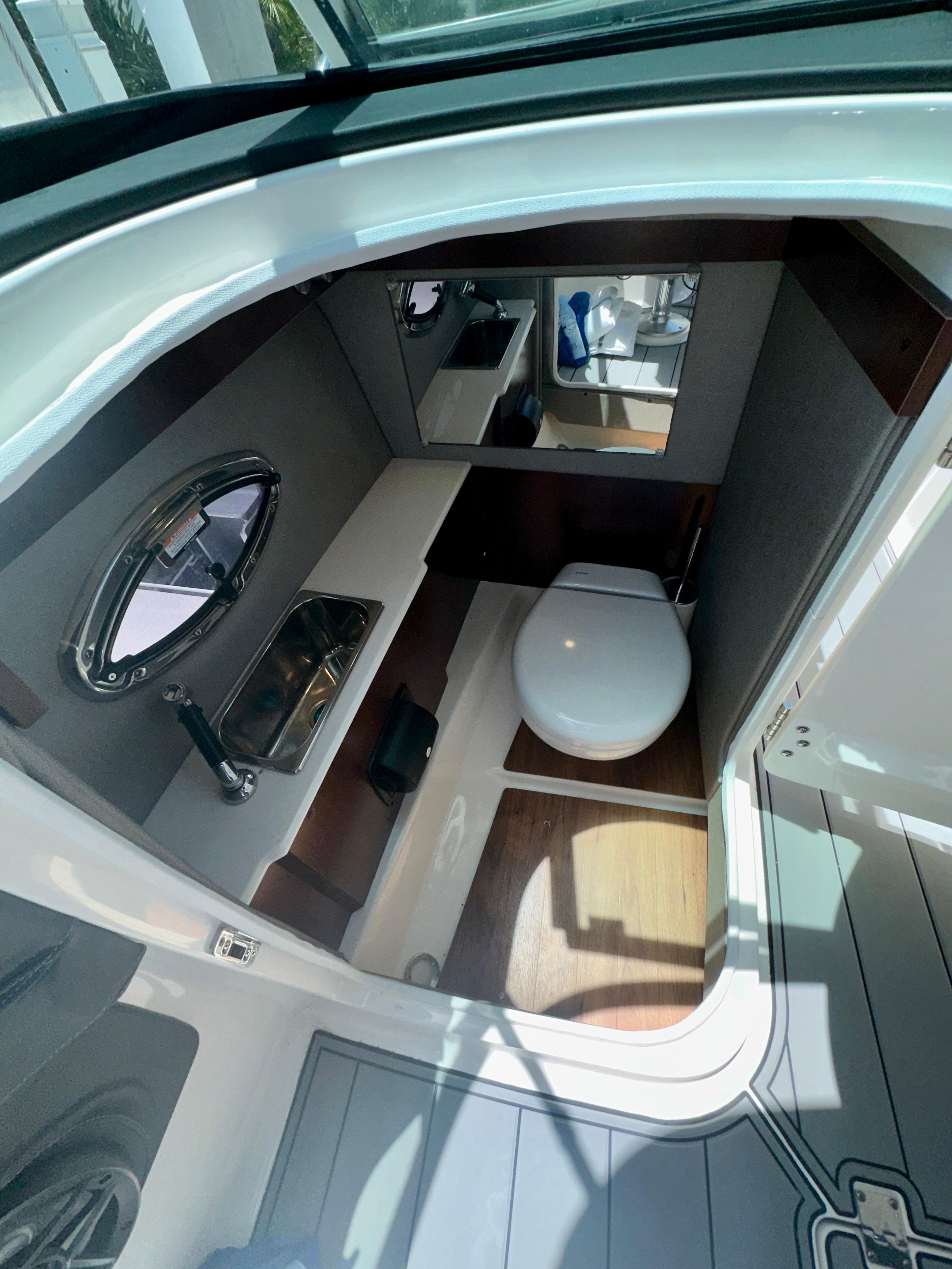 2022 Chaparral 267 SSX OB boat interior bathroom with sink and toilet.