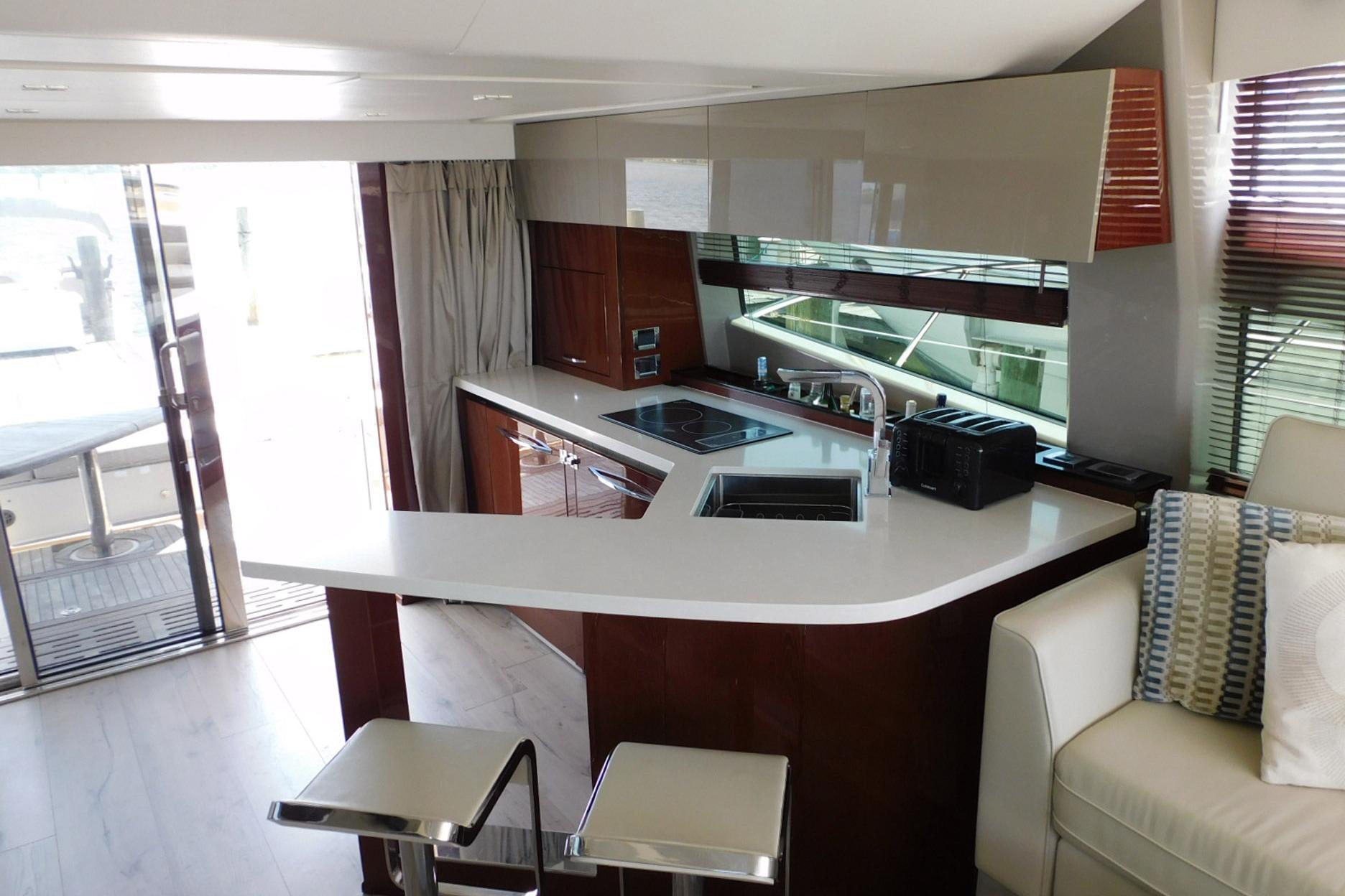Luxurious interior of 2019 Sea Ray L550 yacht featuring modern kitchen and seating area.