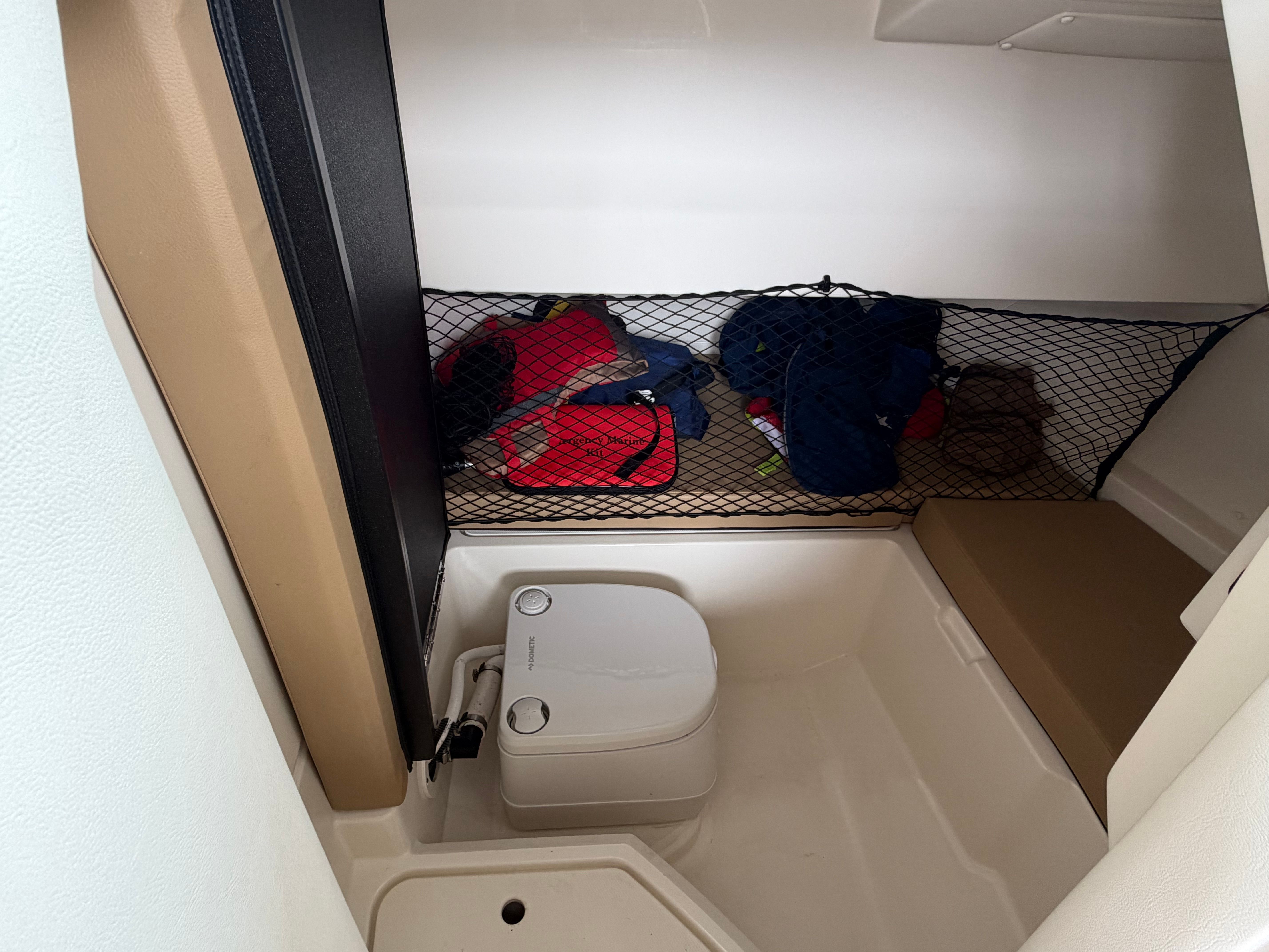 Interior of 2020 Sea Ray SDX 250 Outboard with storage and toilet.