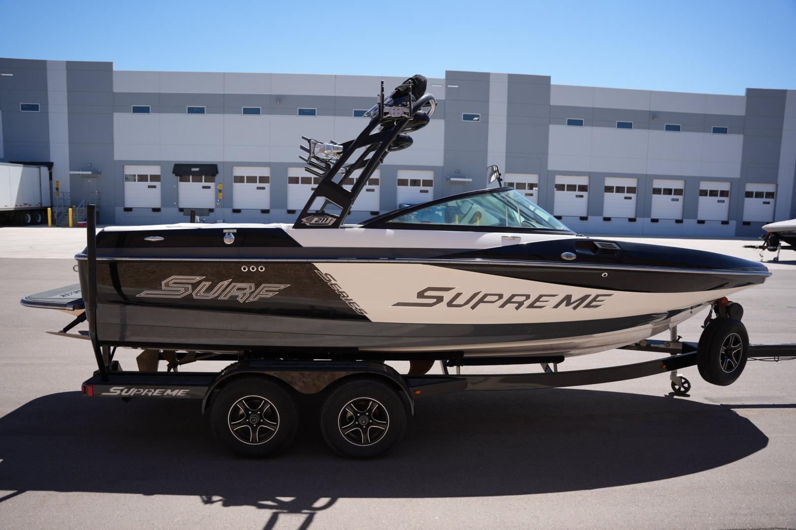 2016 Supreme S211 boat on trailer, parked in industrial area.