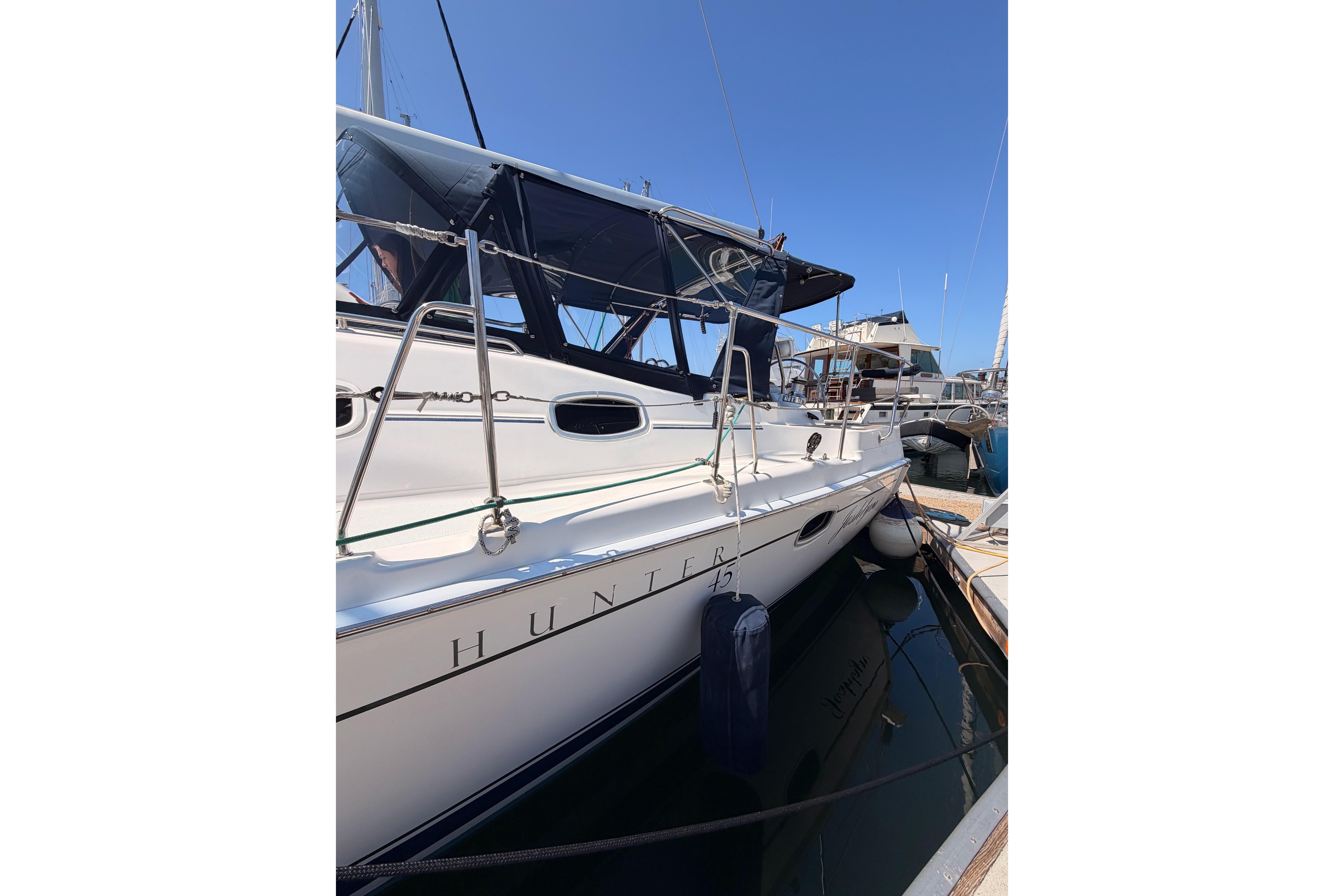 2008 Hunter 45 Deck Salon yacht docked at marina under clear blue sky.