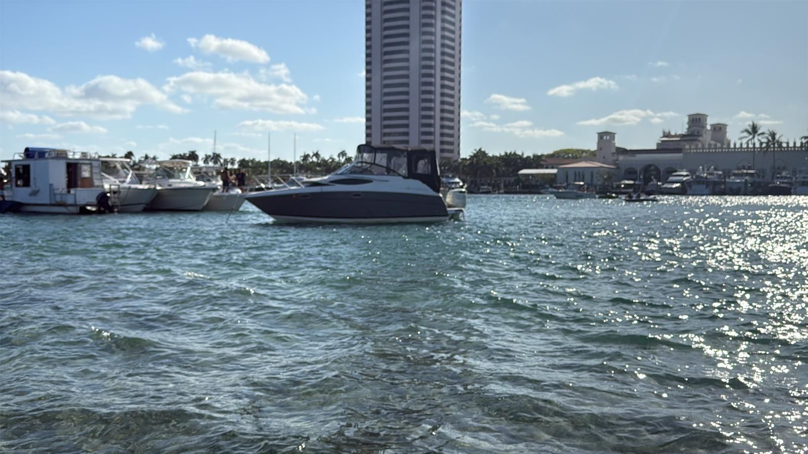 A 2008 Regal 2565 Window Express boat floats on the water against an urban backdrop.